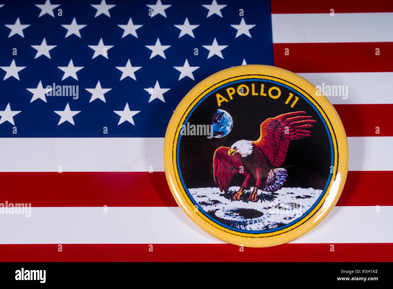 London, Regno Unito - 15 Novembre 2018: il monogramma della storica Apollo 11 sbarco sulla luna, nella foto sopra la bandiera degli Stati Uniti d'America. Foto Stock