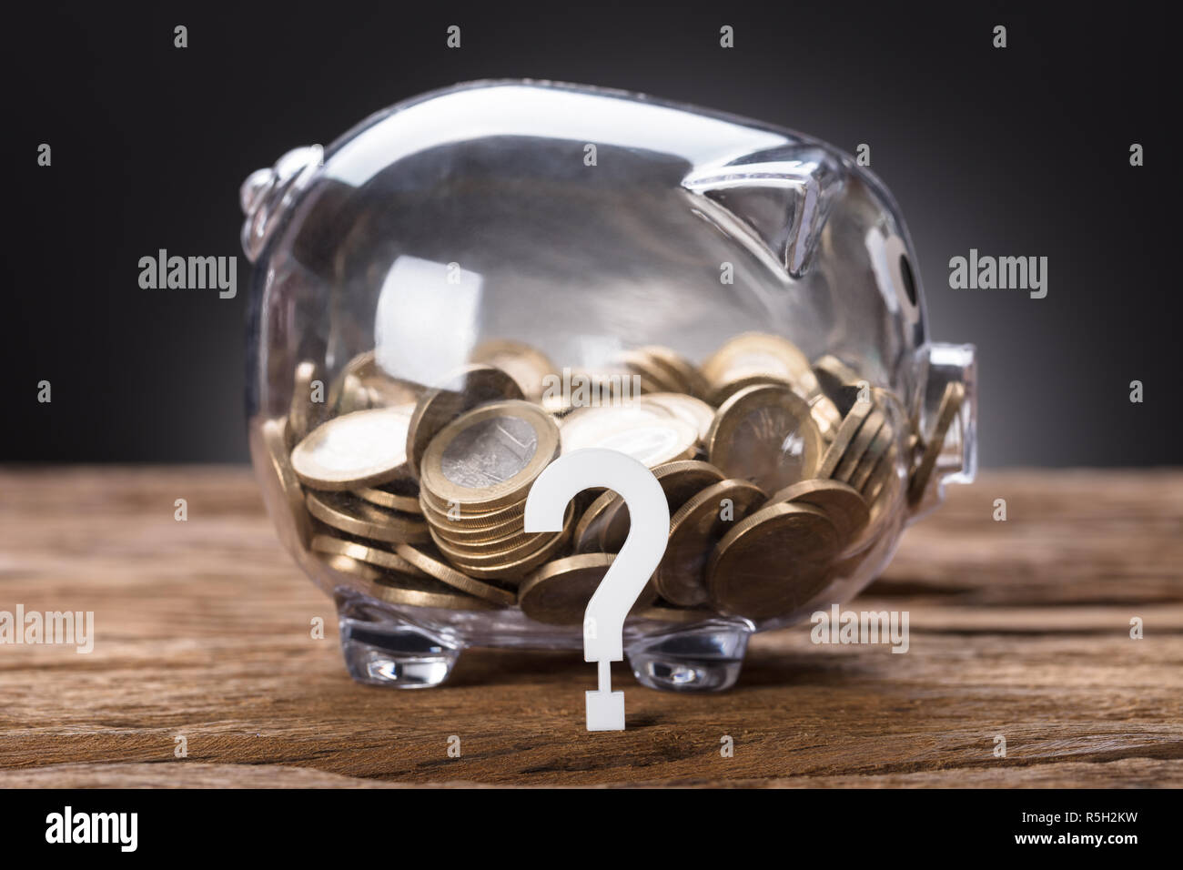 Punto interrogativo e monete in trasparente Salvadanaio Foto Stock