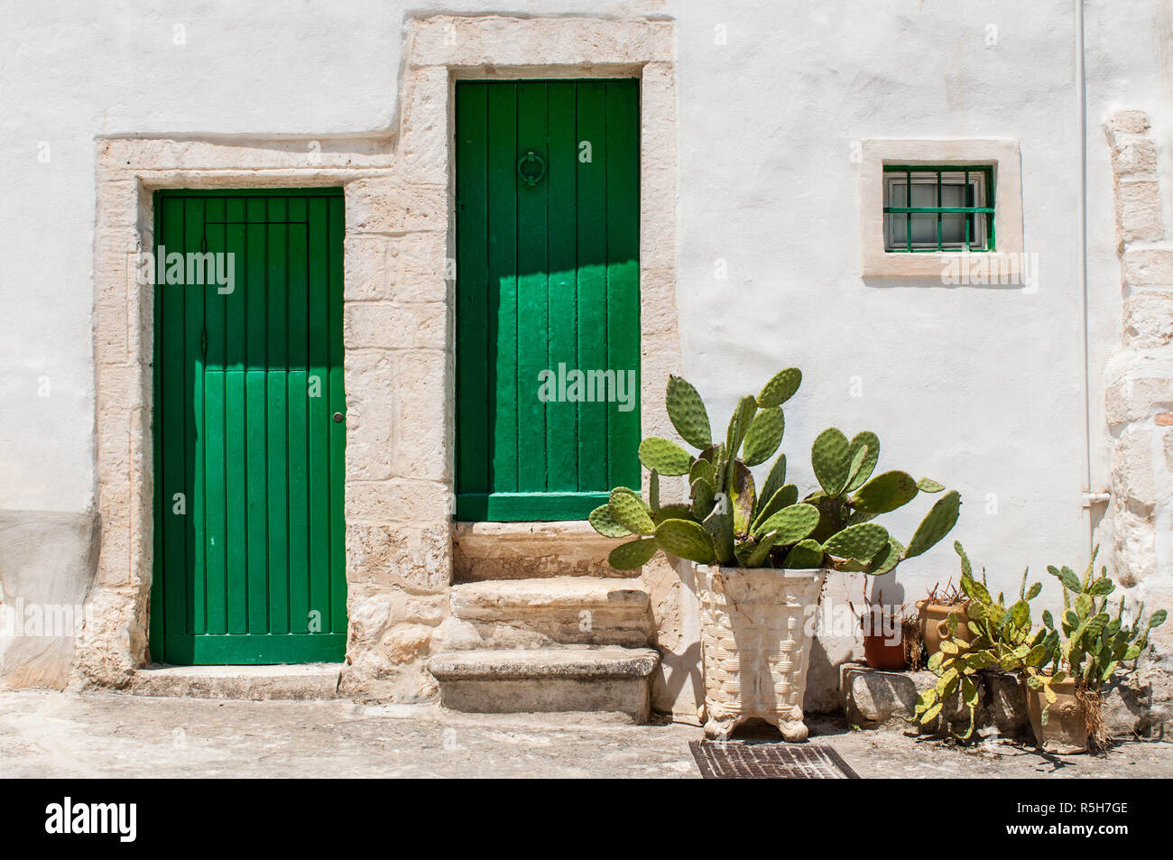 Casa bianca facciata a parete, porta verde e persiane Foto Stock