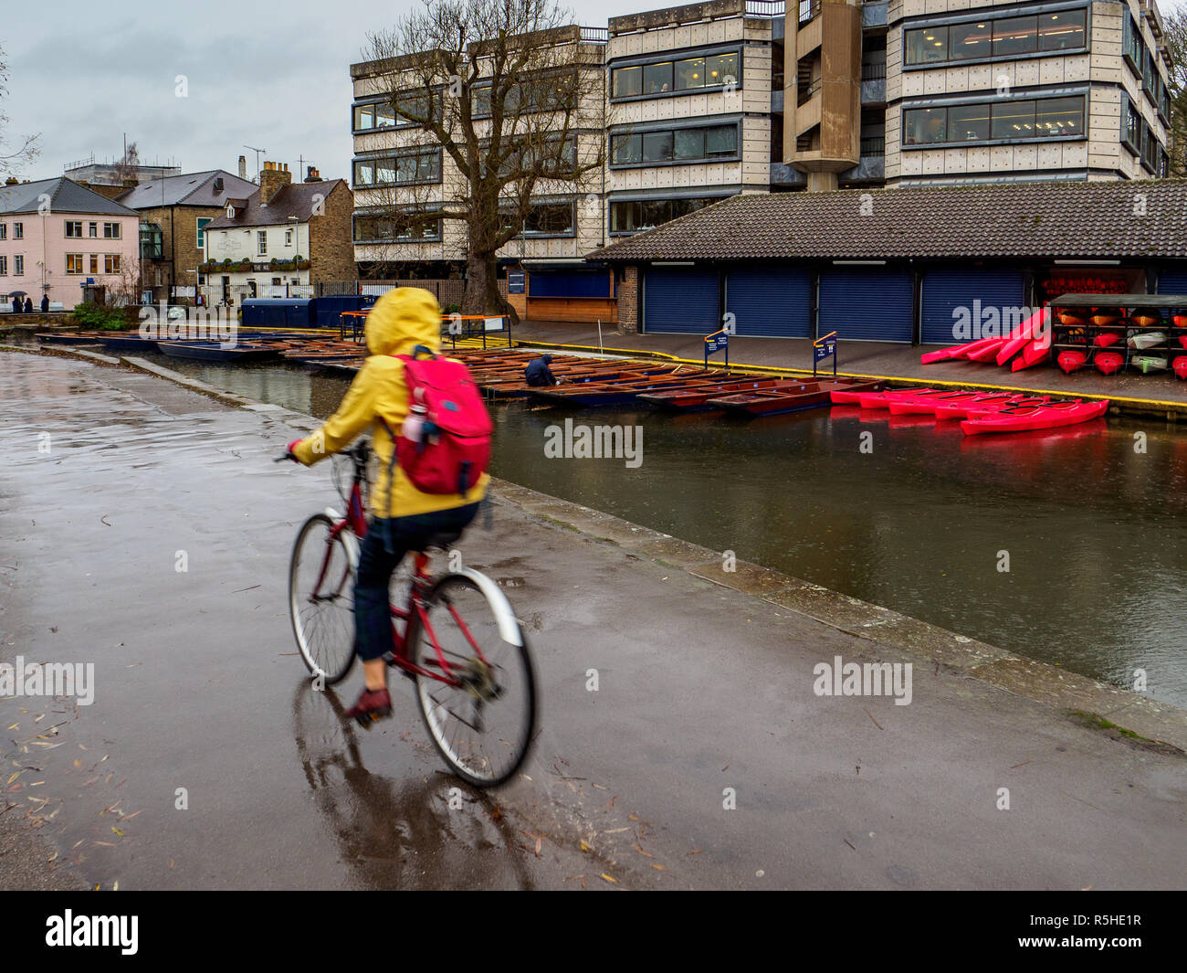 In bicicletta nella Rain accanto alla River Cam nel centro di Cambridge, nel Regno Unito. Giornata delle piogge a Cambridge. Foto Stock
