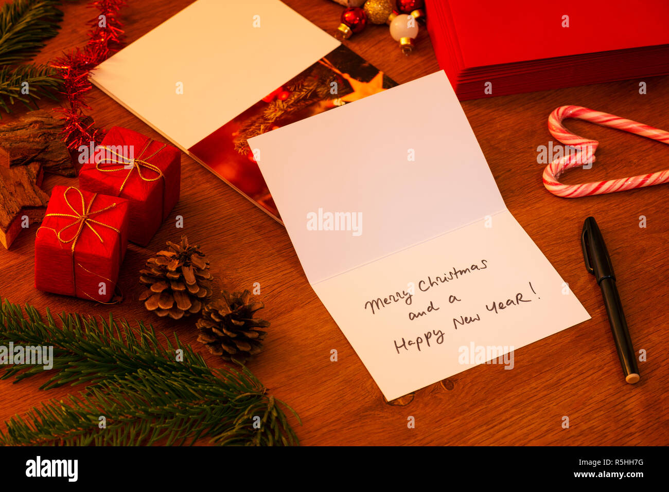 Manoscritta carta natale, appena firmato con un marcatore. Pila di altri biglietti e buste in background. Foto sulla parte anteriore della carta è il mio. Foto Stock