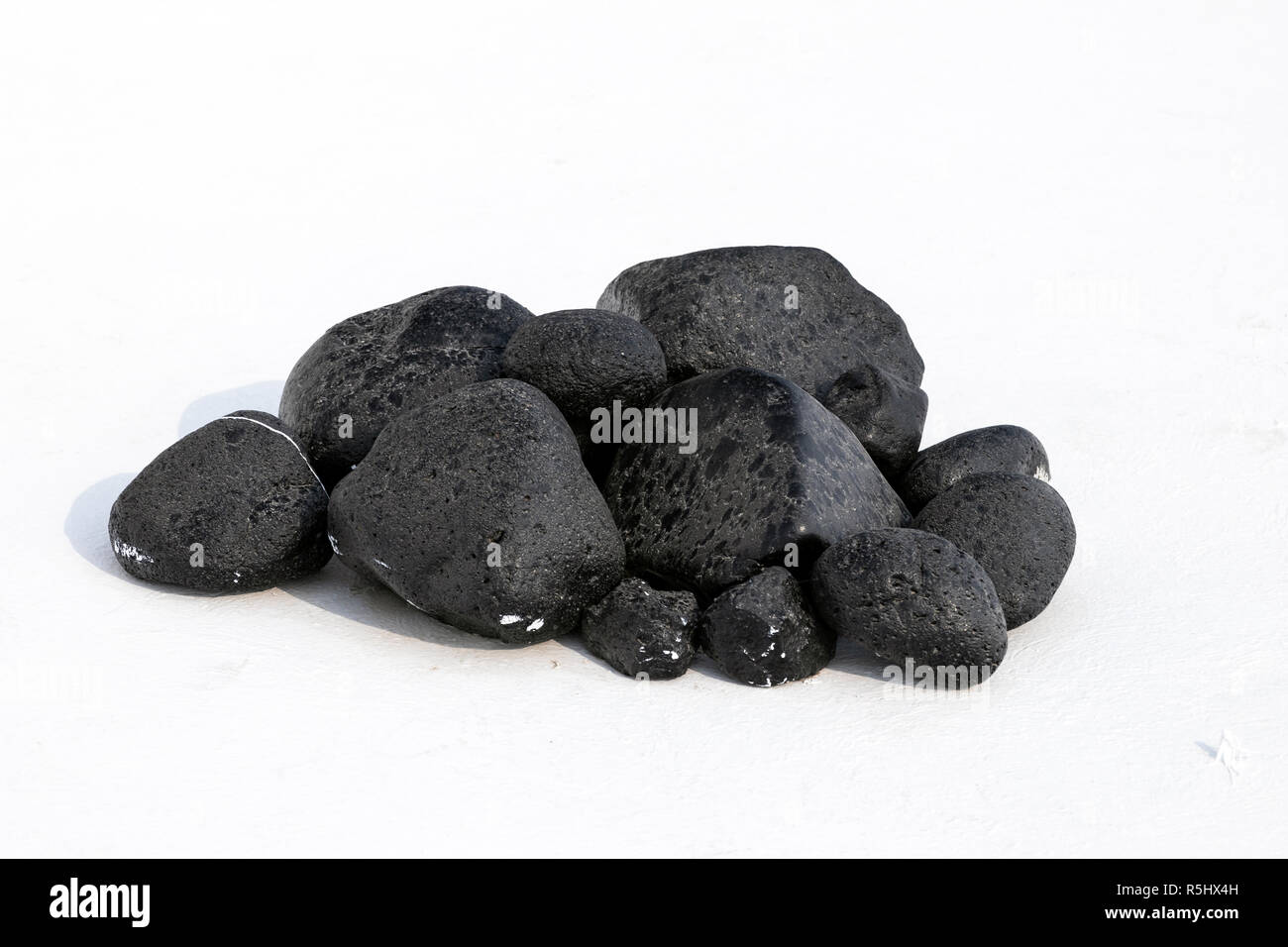 Nero pietre di lava su sfondo bianco Foto Stock