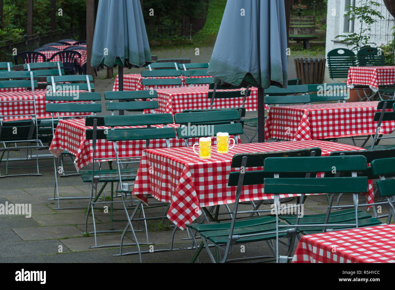 Due grandi brocche di birra su di un giardino della birra tabella Foto Stock