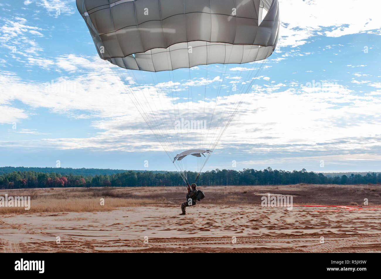 Fort Bragg, NC, Stati Uniti d'America. 30 Novembre, 2018. Dal 1 dicembre 2018 - Fort Bragg, N.C., STATI UNITI D'AMERICA - STATI UNITI Paracadutista esercito sbarca in Sicilia la zona di caduta durante la ventunesima edizione del Randy Oler Memorial il funzionamento del giocattolo Drop, ospitato dall'U.S. Esercito degli affari civili e le operazioni psicologiche il comando (Airborne). La manifestazione annuale, classificato come il più grande del mondo di combinata airborne operazione con i paracadutisti da 13 nazioni alleate, consente di paracadutisti per donare giocattoli per Natale per aiutare i bambini nelle comunità che circondano Fort Bragg. Paesi partecipanti quest'anno incluso: Botswana, Brasile, Canada, Colombia, Cote d' Foto Stock