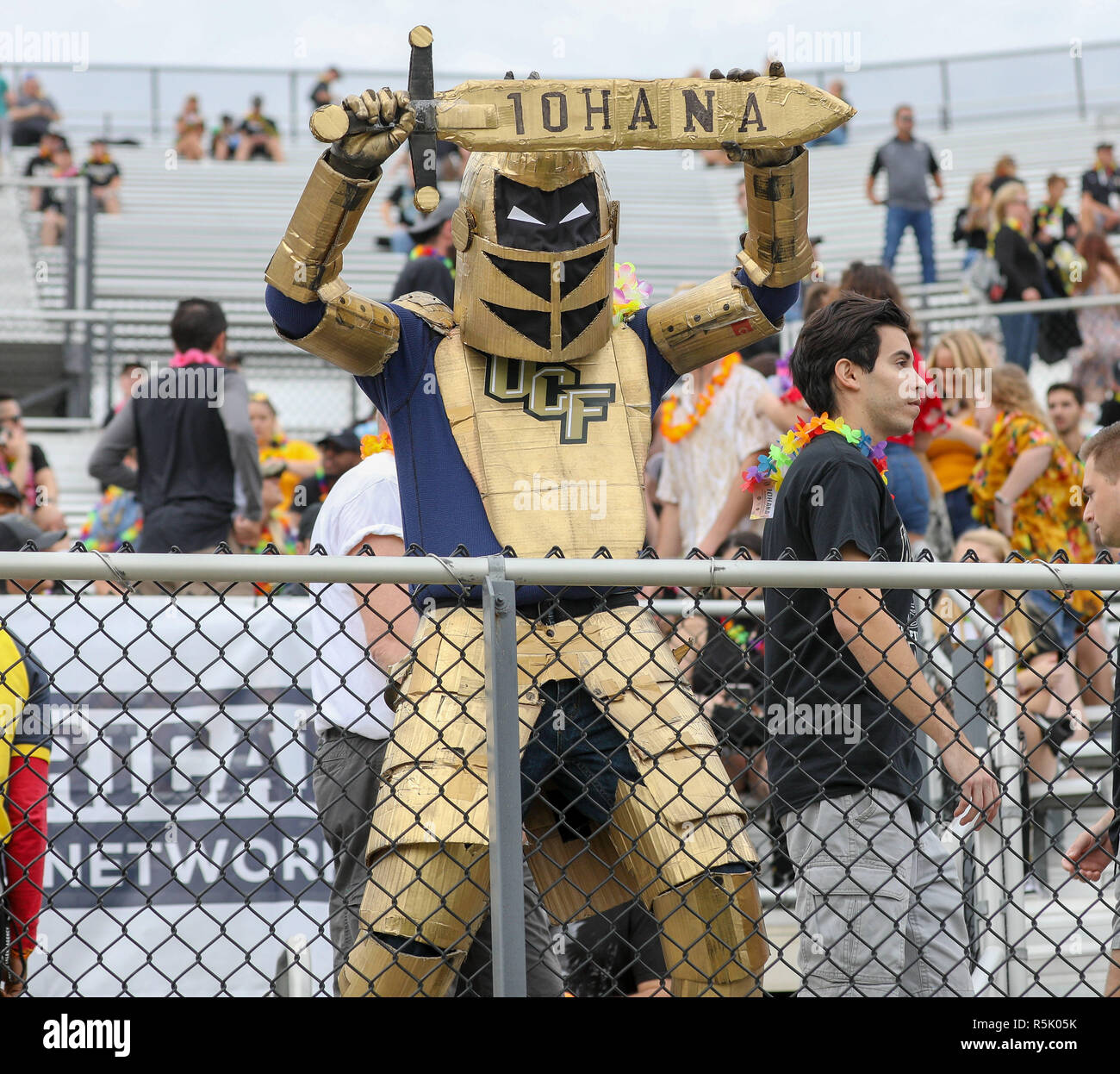 Orlando, Florida, Stati Uniti d'America. 1 dicembre, 2018. Una ventola nella Sezione studenti è vestito come UCF Cavaliere della mascotte e contiene un omaggio ai feriti UCF quarterback McKenzie Milton (che viene dalle Hawaii) prima del calcio di AAC partita di campionato tra il Tigri di Memphis e la UCF Cavalieri presso lo Stadio dello spettro in Orlando, Florida. Kyle Okita/CSM/Alamy Live News Foto Stock