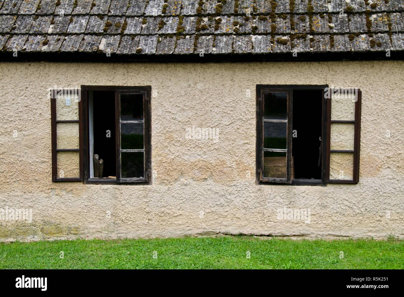 Le finestre aperte in una crema europea cottage in pietra Foto Stock