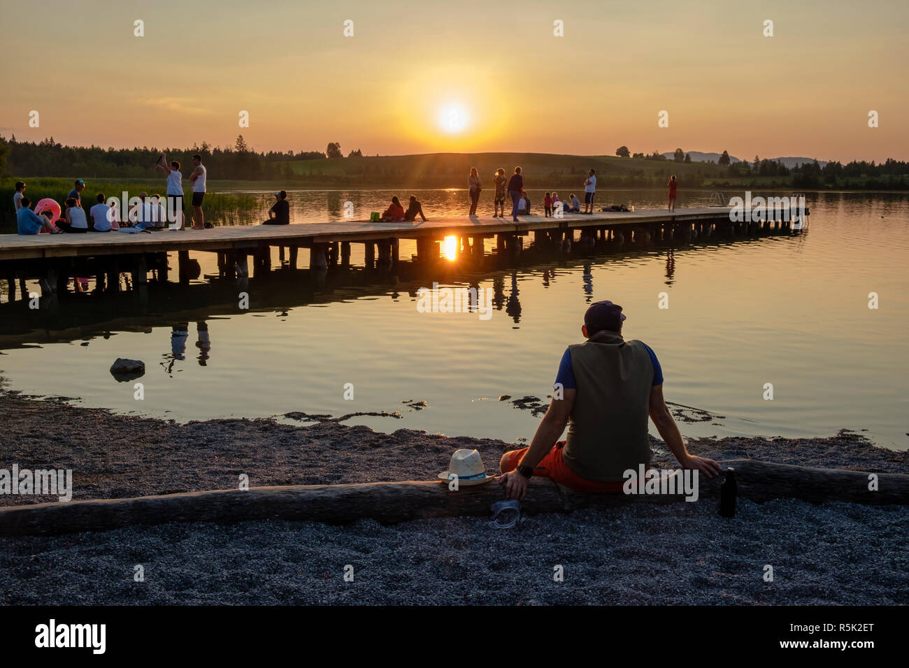 I villeggianti guardare il tramonto sopra Bannwaldsee, Schwangau, Baviera, Germania Foto Stock