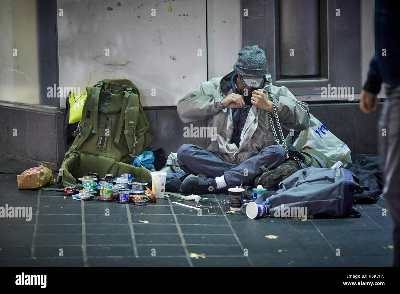 Il centro di Liverpool senzatetto di accattonaggio uomo con il disordine intorno a lui come egli implora Foto Stock