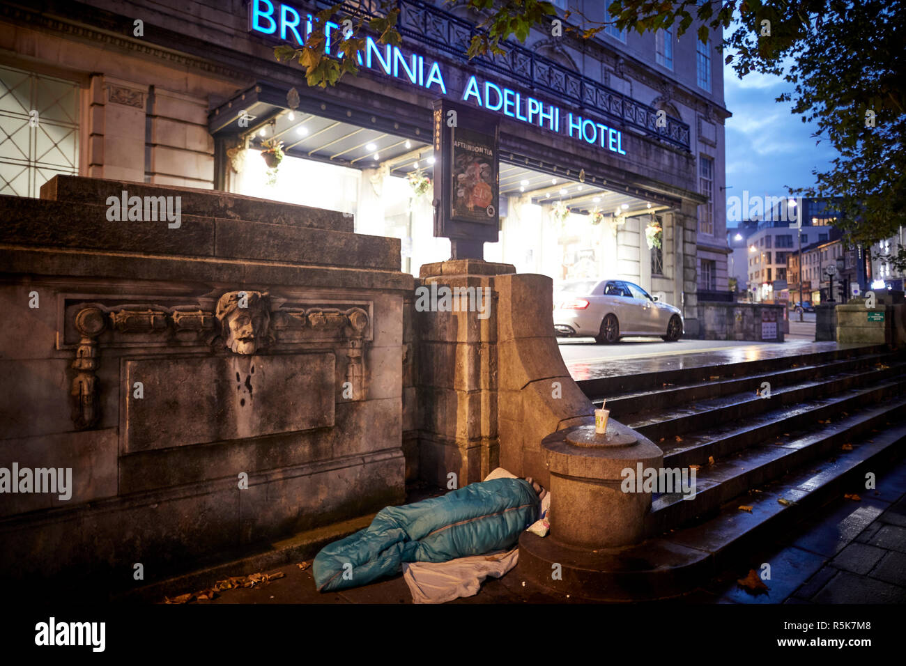 Il centro di Liverpool un senzatetto dormire in un sonno torna sul marciapiede esterno iconico Britannia Adelphi Hotel passi Foto Stock