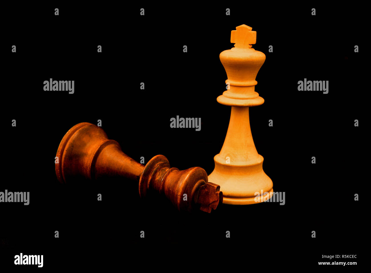 Re Nero surreder al re bianco alla fine del gioco. Due strandard di scacchi pezzi di legno su sfondo nero Foto Stock