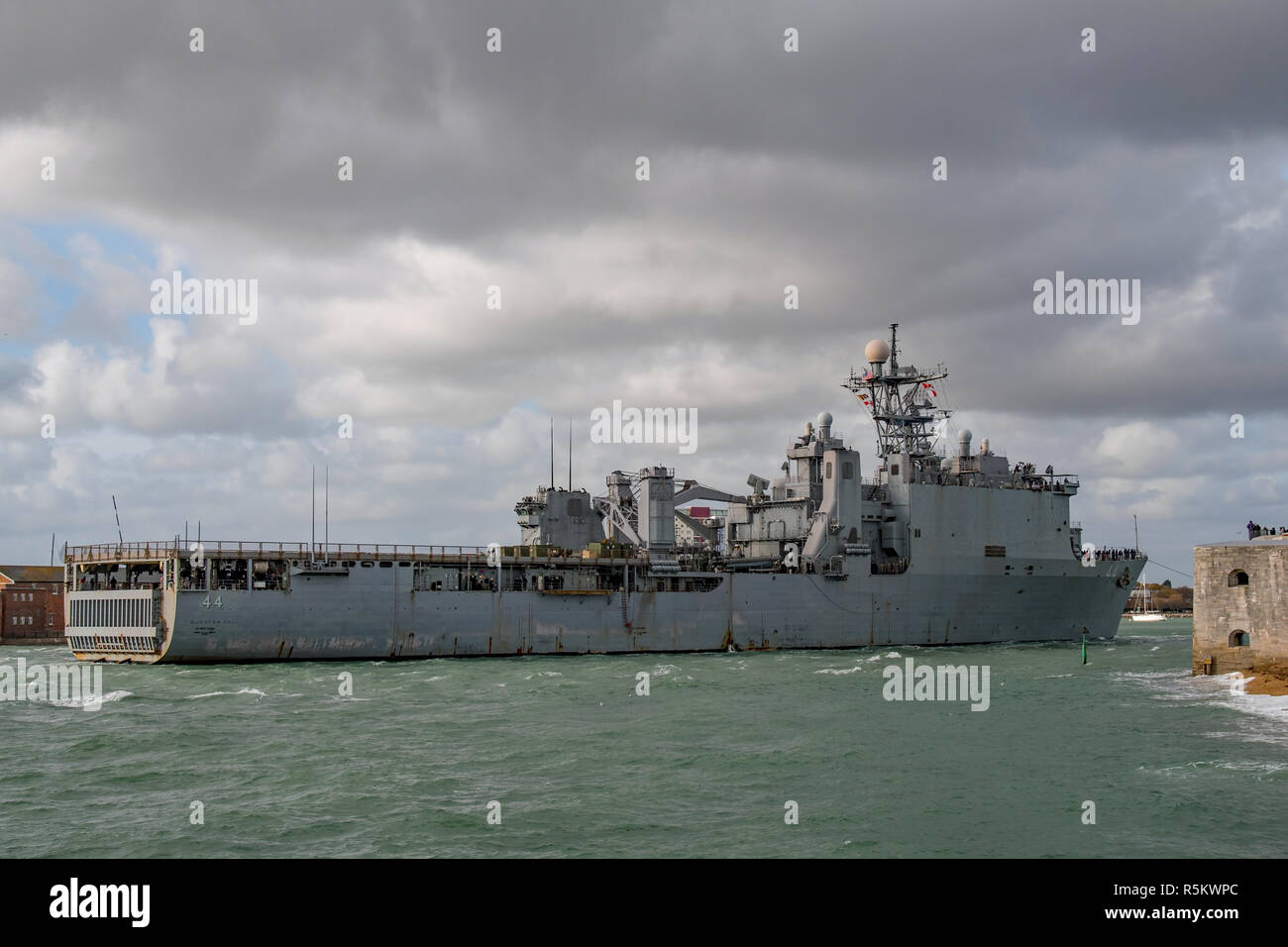 La Marina degli Stati Uniti dock landing ship USS Gunston Hall passando le pareti calde e torre rotonda all'ingresso al porto di Portsmouth, Regno Unito su 9/11/18. Foto Stock