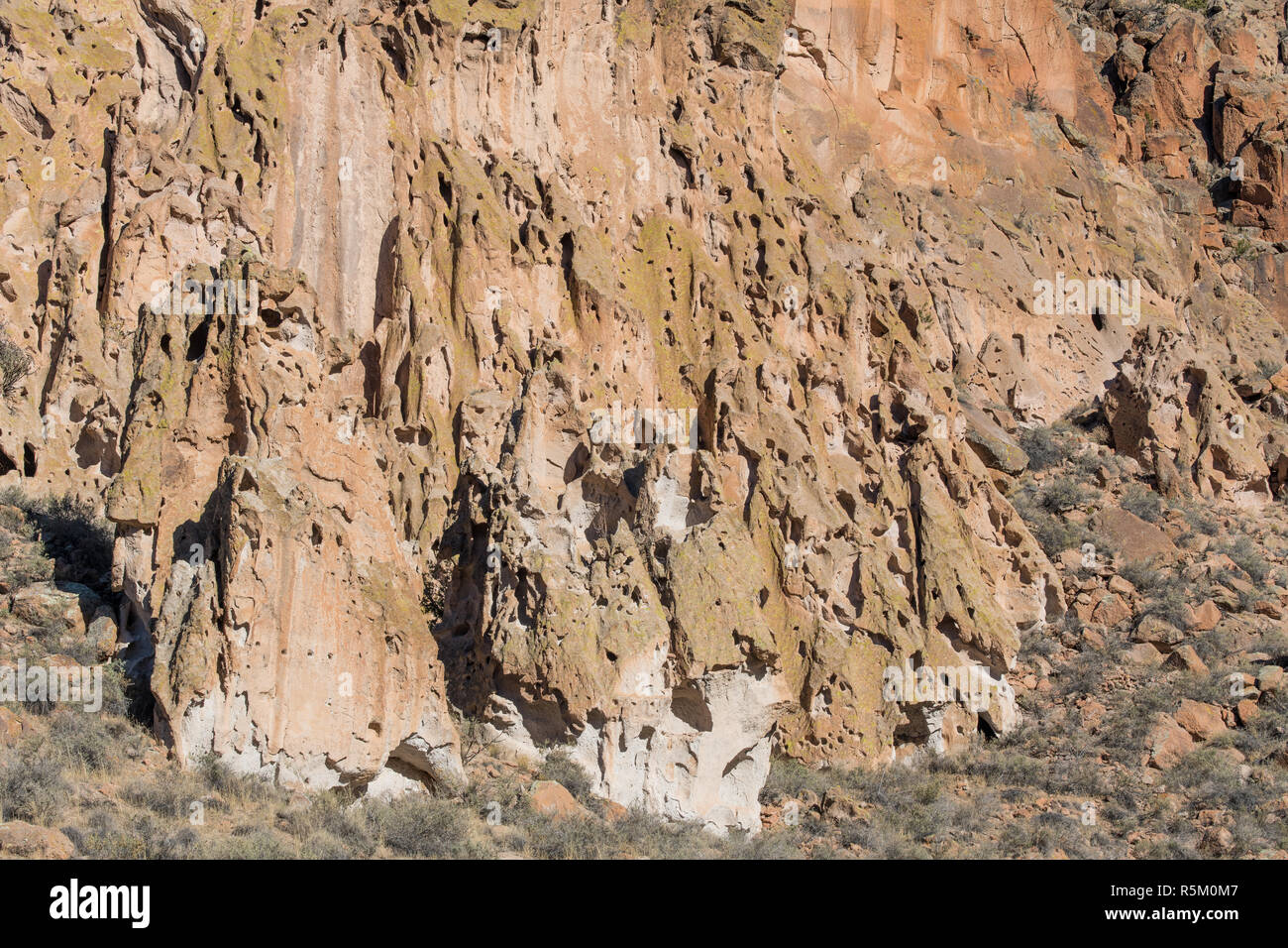 Insolito, tufo colorate formazioni rocciose e le scogliere con un modello di confusione di erosione dei fori e piccole grotte in Bandelier National Monument Foto Stock