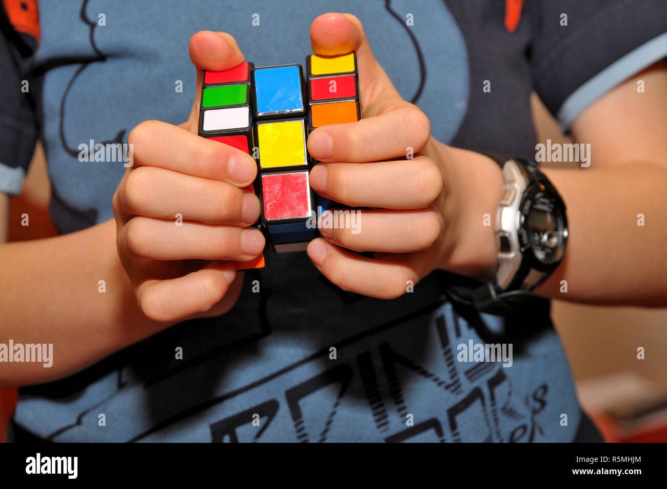 Un ragazzo che gioca con un cubo di Rubik puzzle. Foto Stock