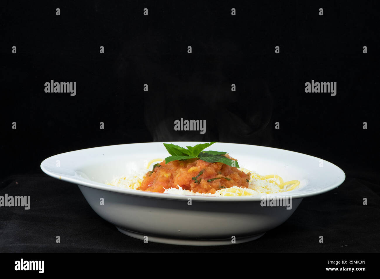 Spaghetti con pomodoro fresco e basilico e triturato halloumi sulla parte superiore Foto Stock