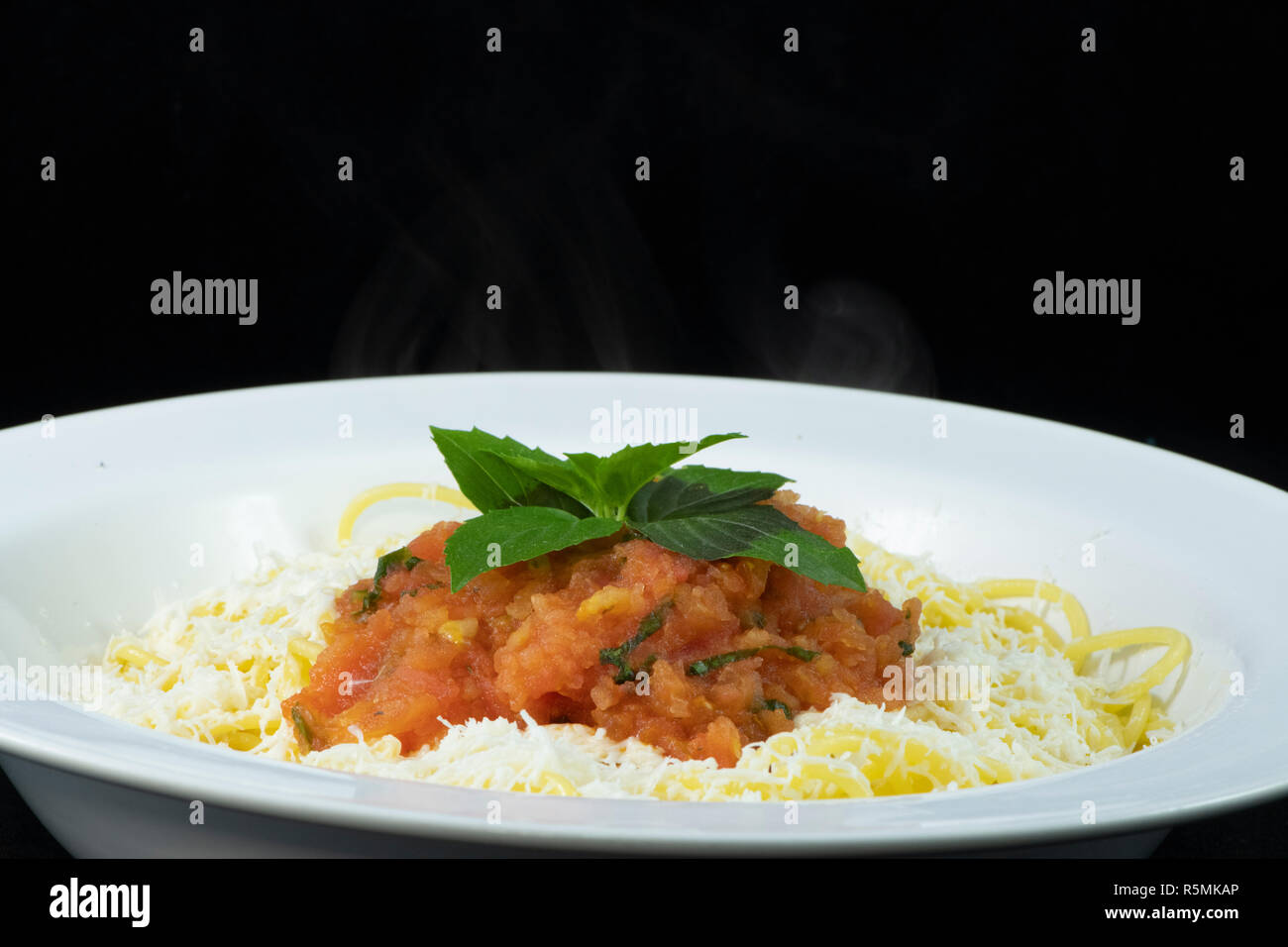 Spaghetti con pomodoro fresco e basilico e triturato halloumi sulla parte superiore Foto Stock