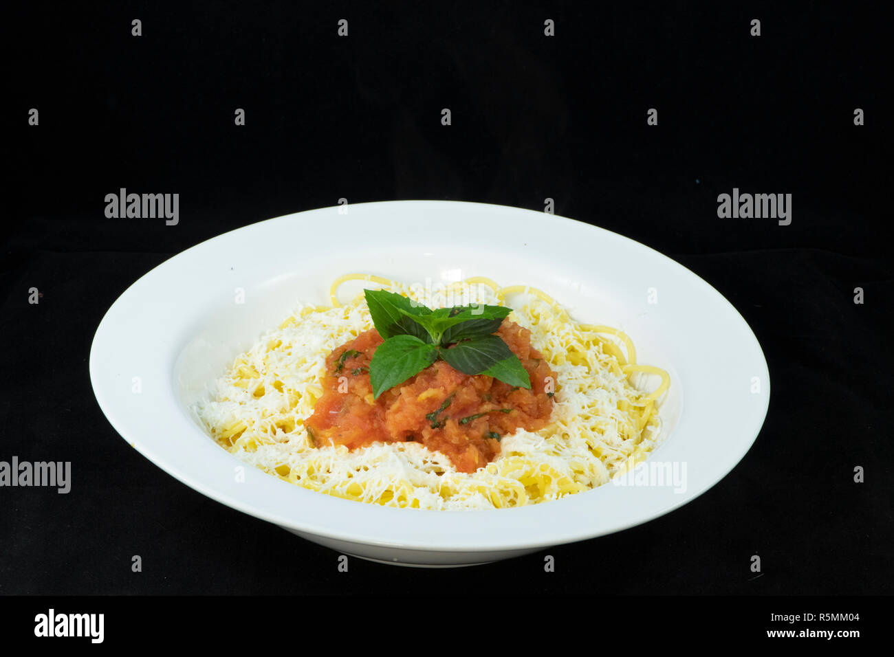 Spaghetti con pomodoro fresco e basilico e triturato halloumi sulla parte superiore Foto Stock