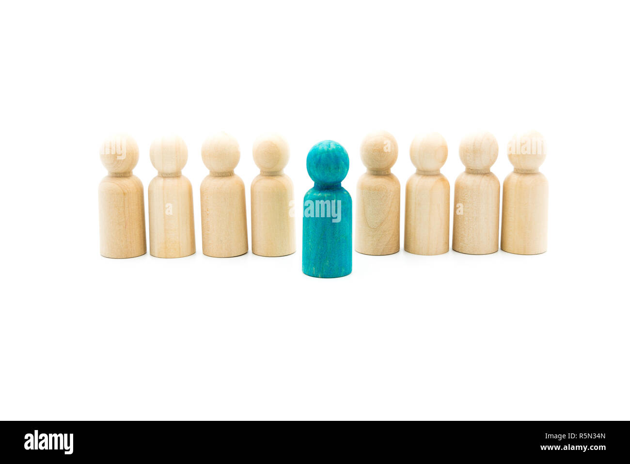 Figure in legno in linea come il team aziendale con una figura blu in piedi fuori dalla folla, isolato su sfondo bianco. Immagine concettuale di essere dif Foto Stock