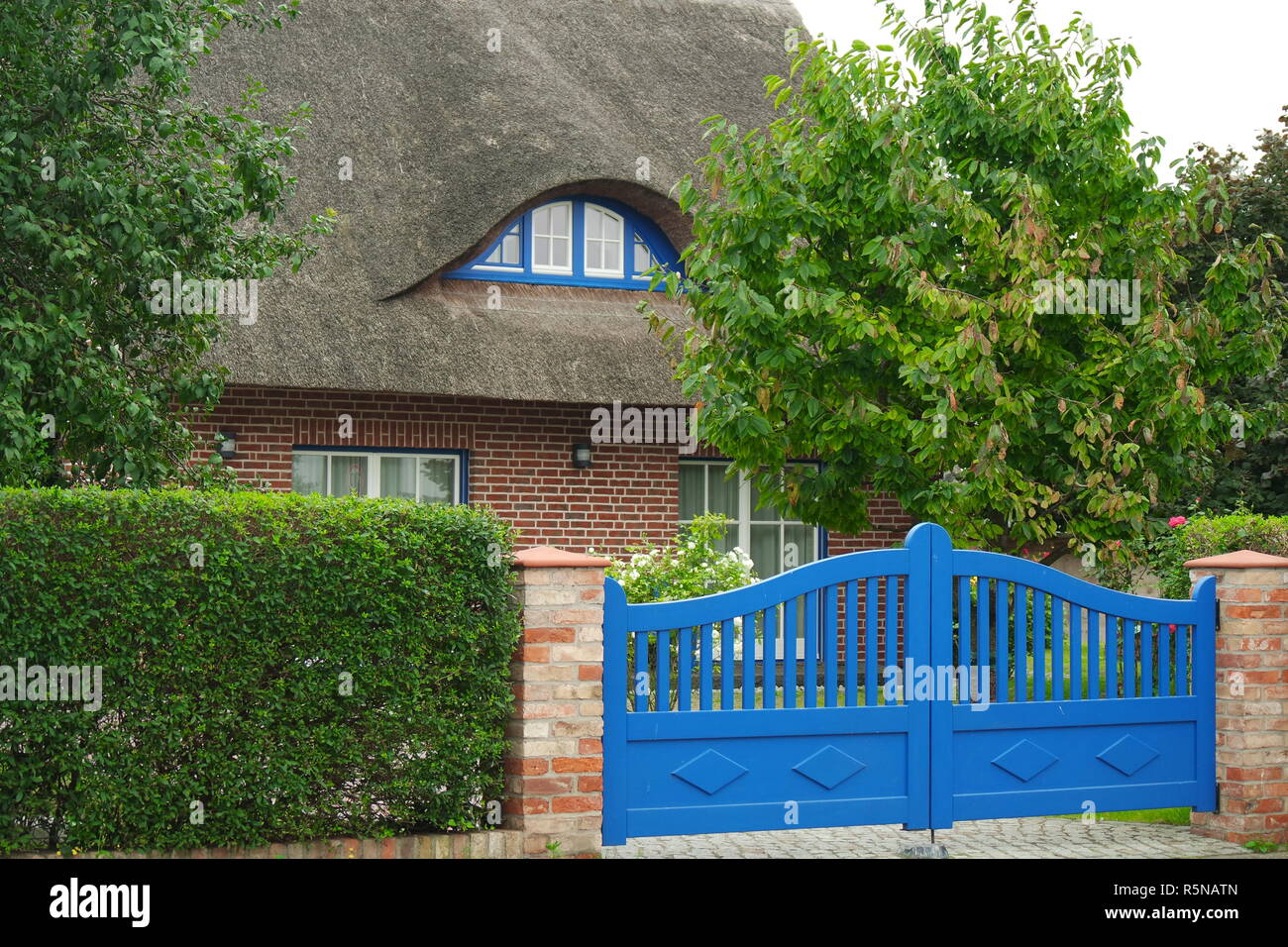 Casa dietro un cancello blu Foto Stock