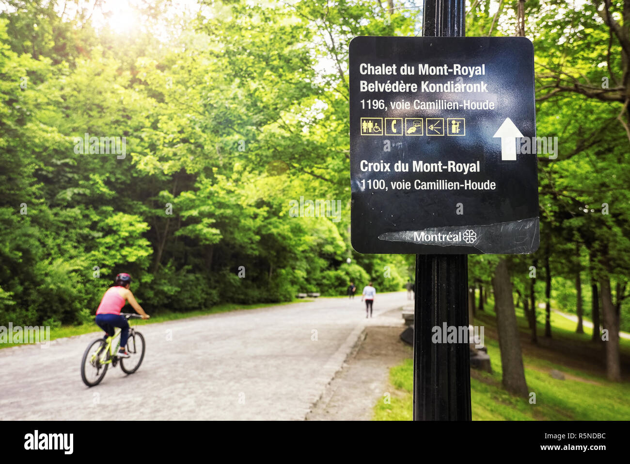 Direzione segno di Mount Royal (Chalet Chalet du Mont-Royal) e un ciclista su strada a Montreal, Canada. Foto Stock