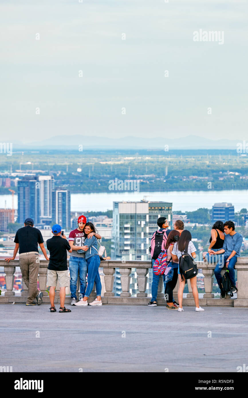 Montreal, Canada - Giugno, 2018: persone in chat, tenendo selfies e guardare il paesaggio cittadino di Montreal da mount royal sulla soleggiata una sera d'estate. Foto Stock