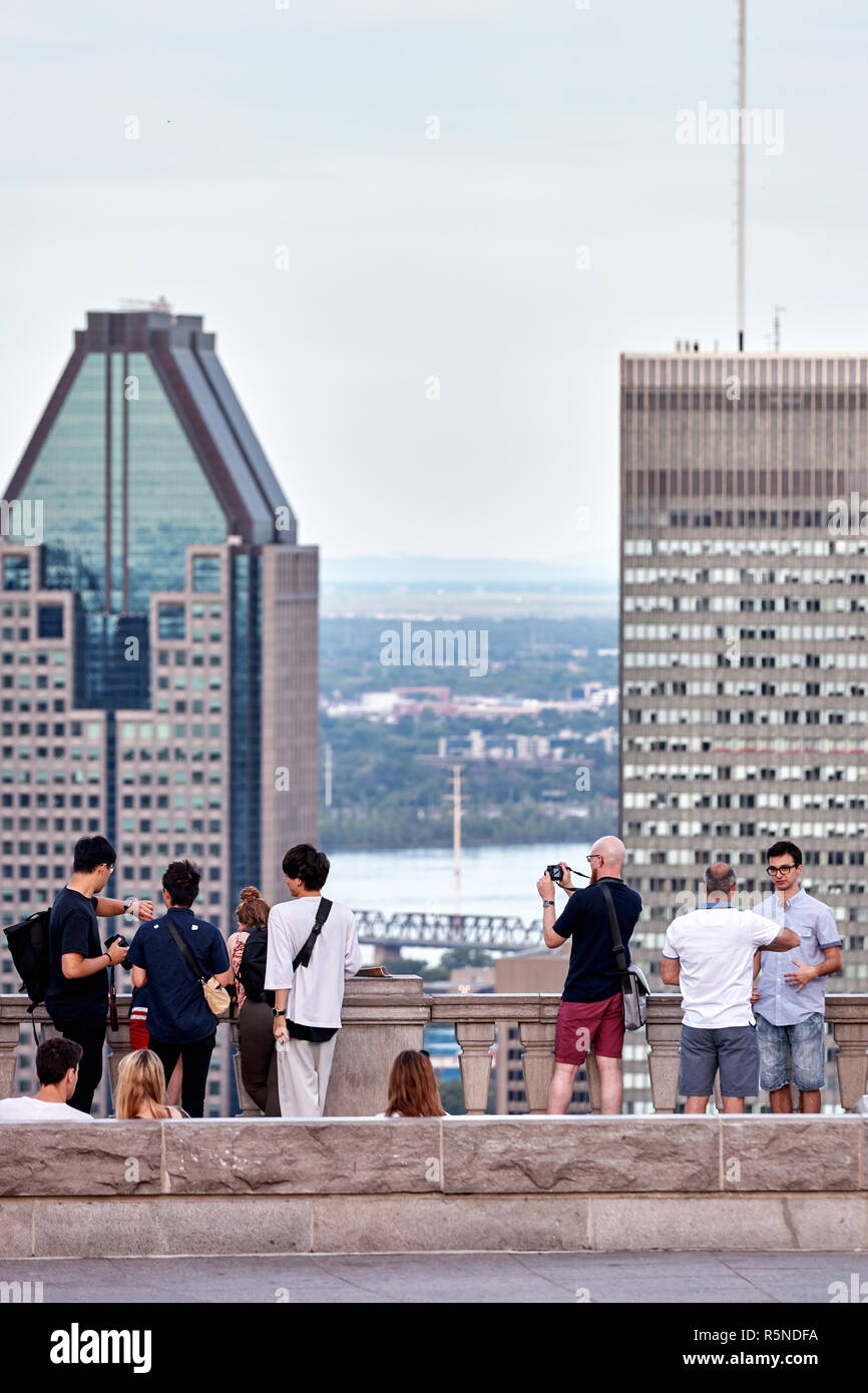 Montreal, Canada - Giugno, 2018: persone in chat, tenendo selfies e guardare il paesaggio cittadino di Montreal da mount royal sulla soleggiata una sera d'estate. Foto Stock