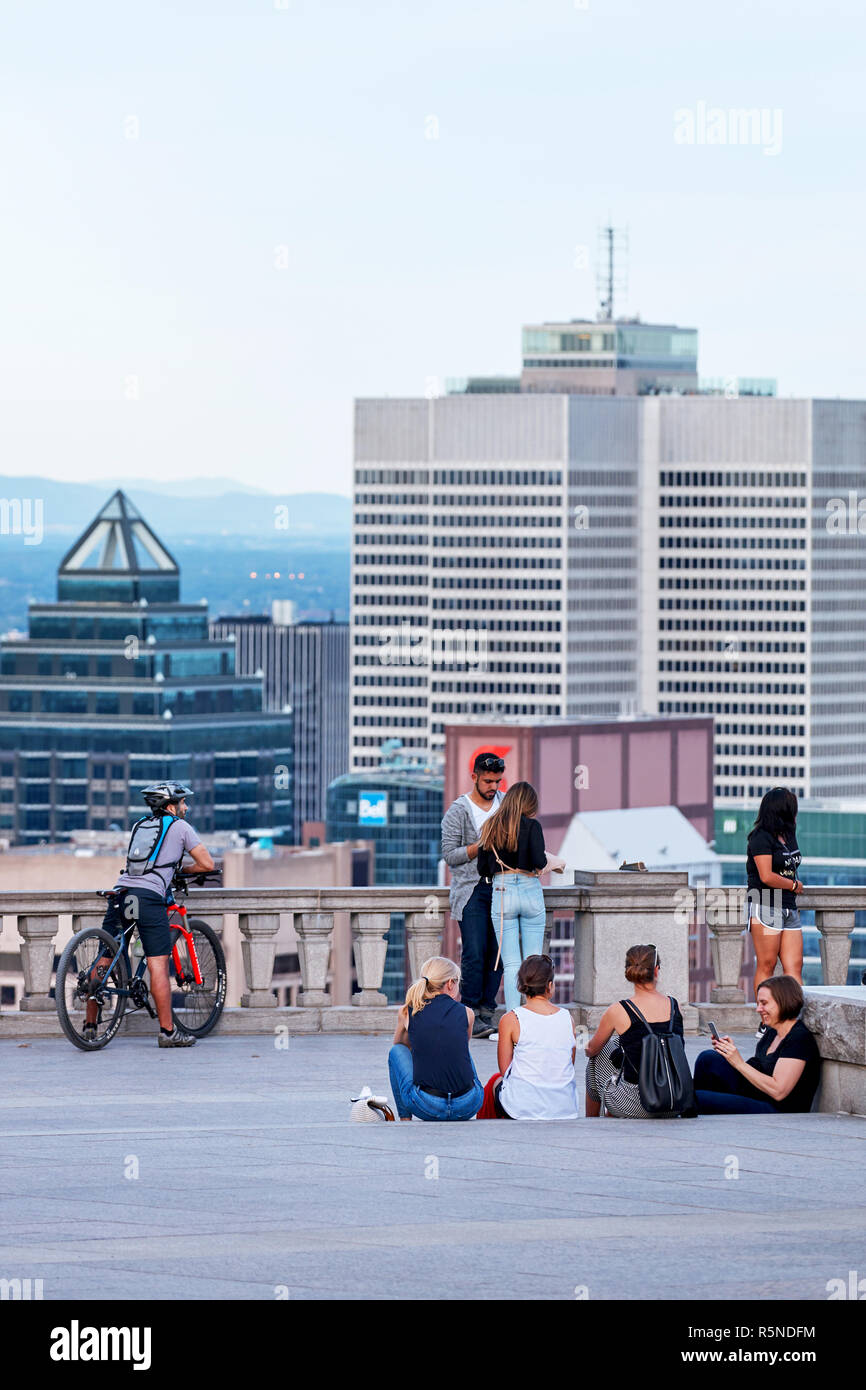 Montreal, Canada - Giugno, 2018: persone in chat, tenendo selfies e guardare il paesaggio cittadino di Montreal da mount royal sulla soleggiata una sera d'estate. Foto Stock