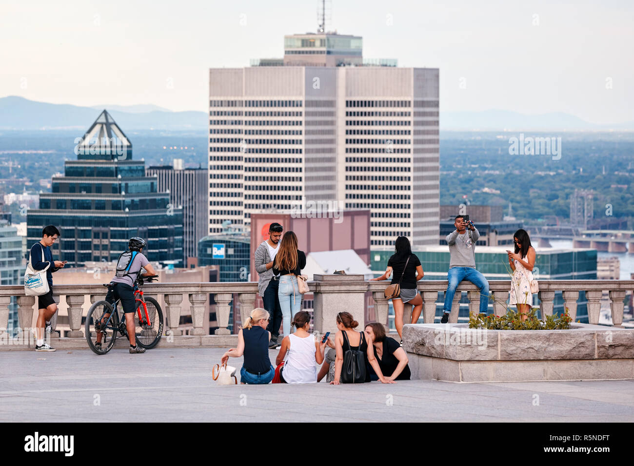 Montreal, Canada - Giugno, 2018: persone in chat, tenendo selfies e guardare il paesaggio cittadino di Montreal da mount royal sulla soleggiata una sera d'estate. Foto Stock