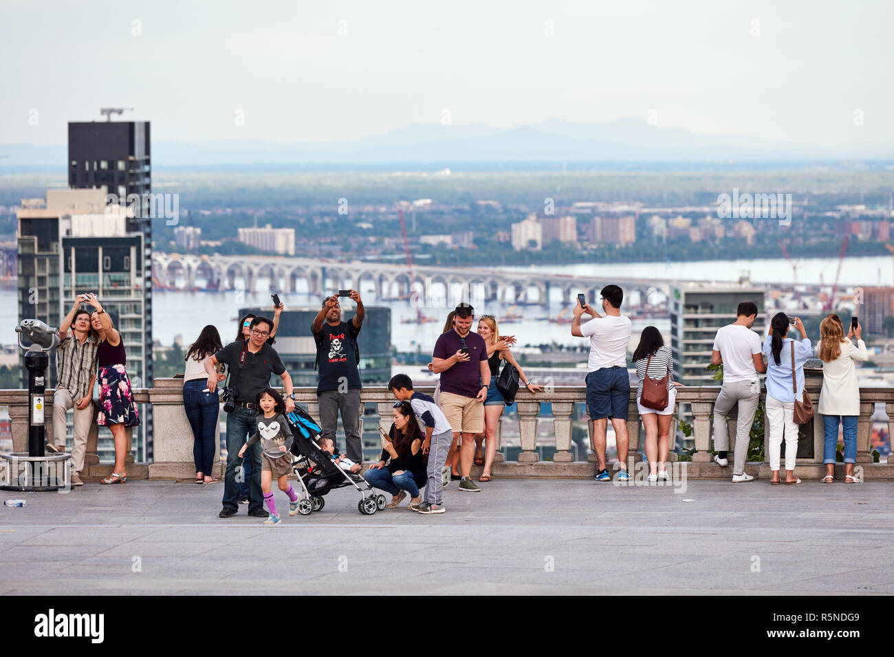 Montreal, Canada - Giugno, 2018: persone in chat, tenendo selfies e guardare il paesaggio cittadino di Montreal da mount royal sulla soleggiata una sera d'estate. Foto Stock