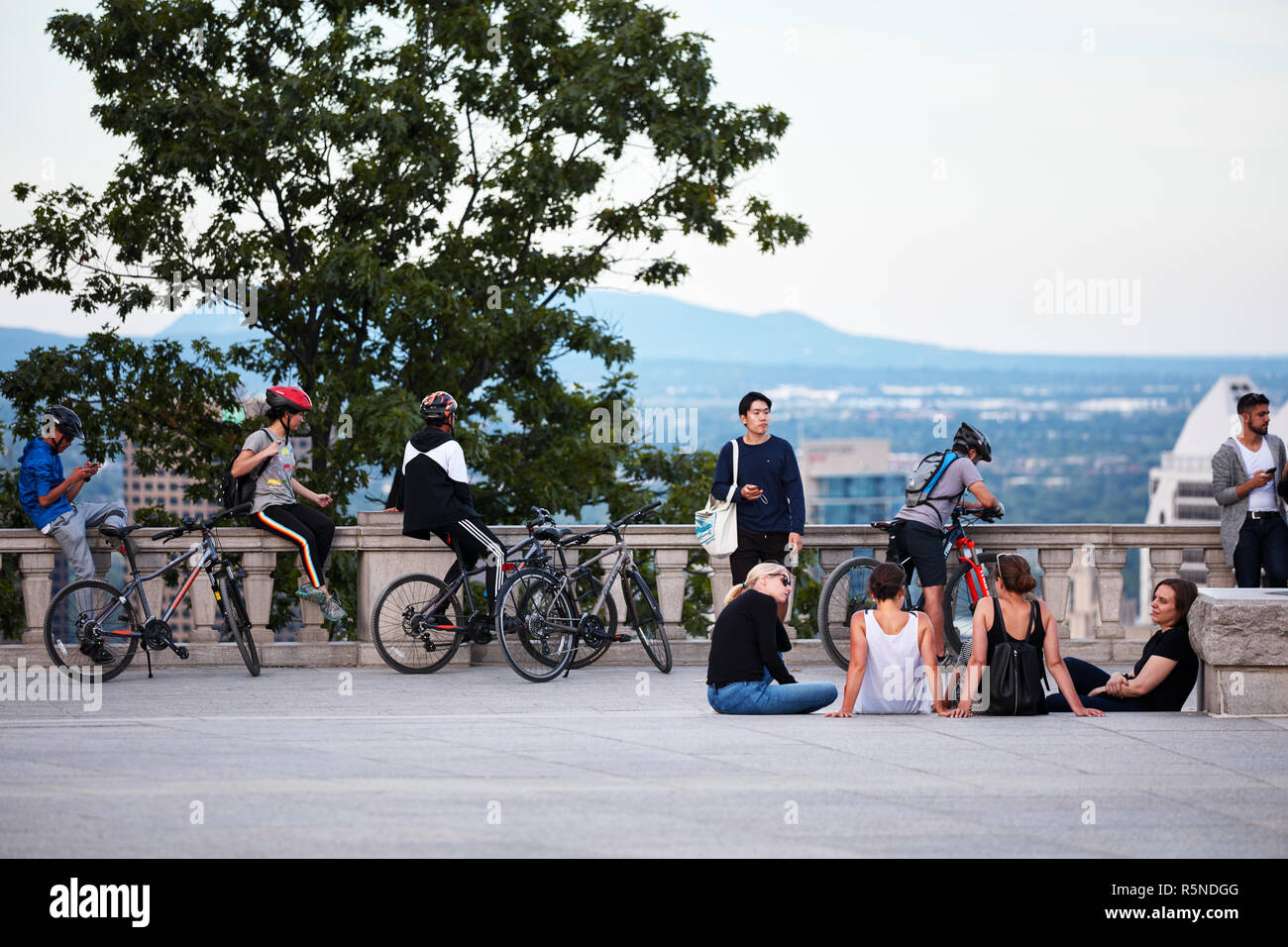 Montreal, Canada - Giugno, 2018: persone in chat, tenendo selfies e guardare il paesaggio cittadino di Montreal da mount royal sulla soleggiata una sera d'estate. Foto Stock