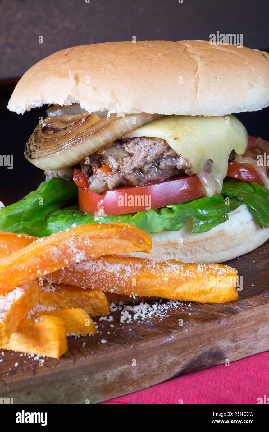 Classico pub Inglese pasto a base di formaggio hamburger con patate dolci patatine fritte e un aglio maionese Foto Stock