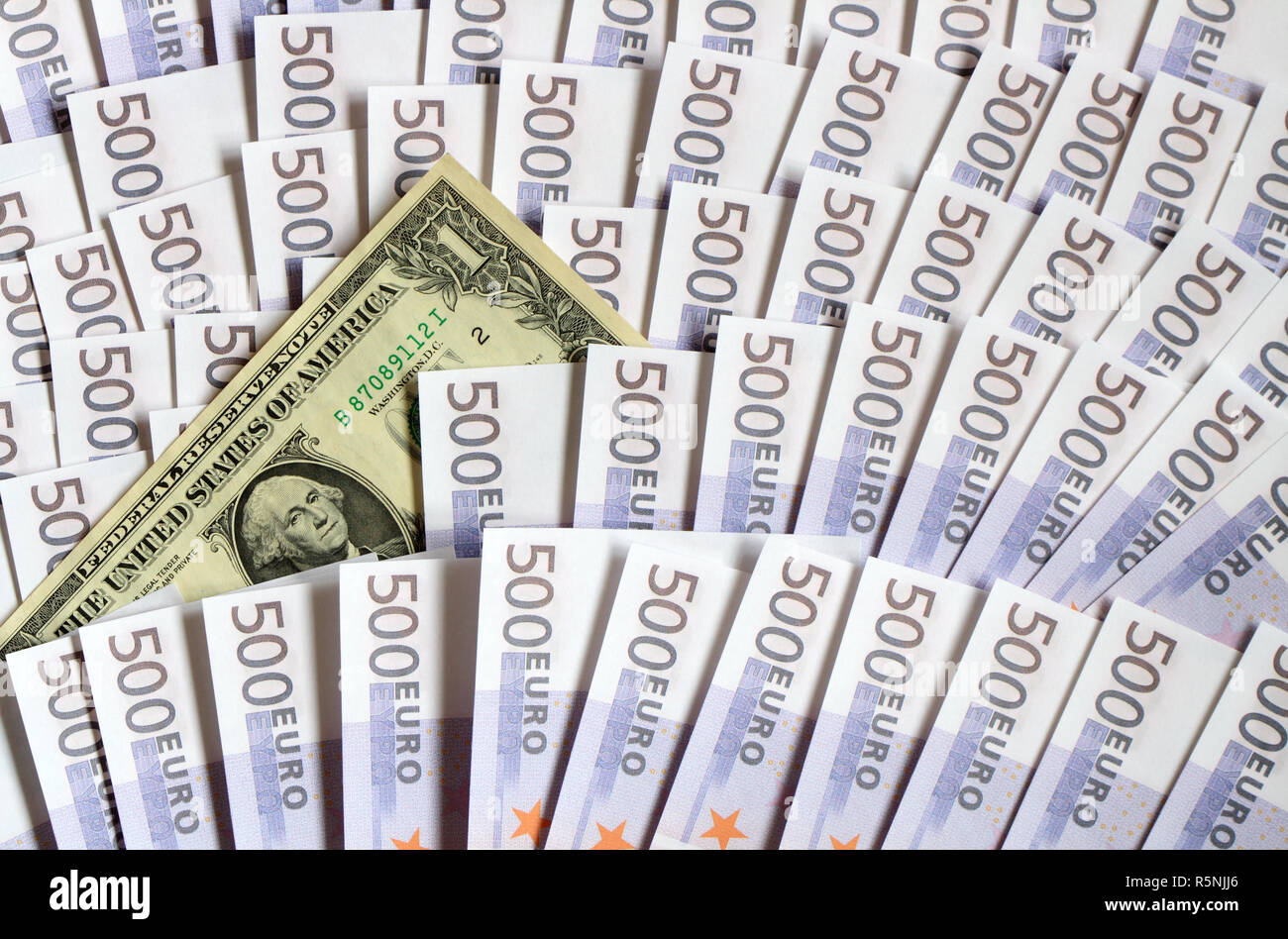 Sfondo costituito da un dollaro banconota giacente sul lotto di cinque centinaia di banconote in euro Foto Stock