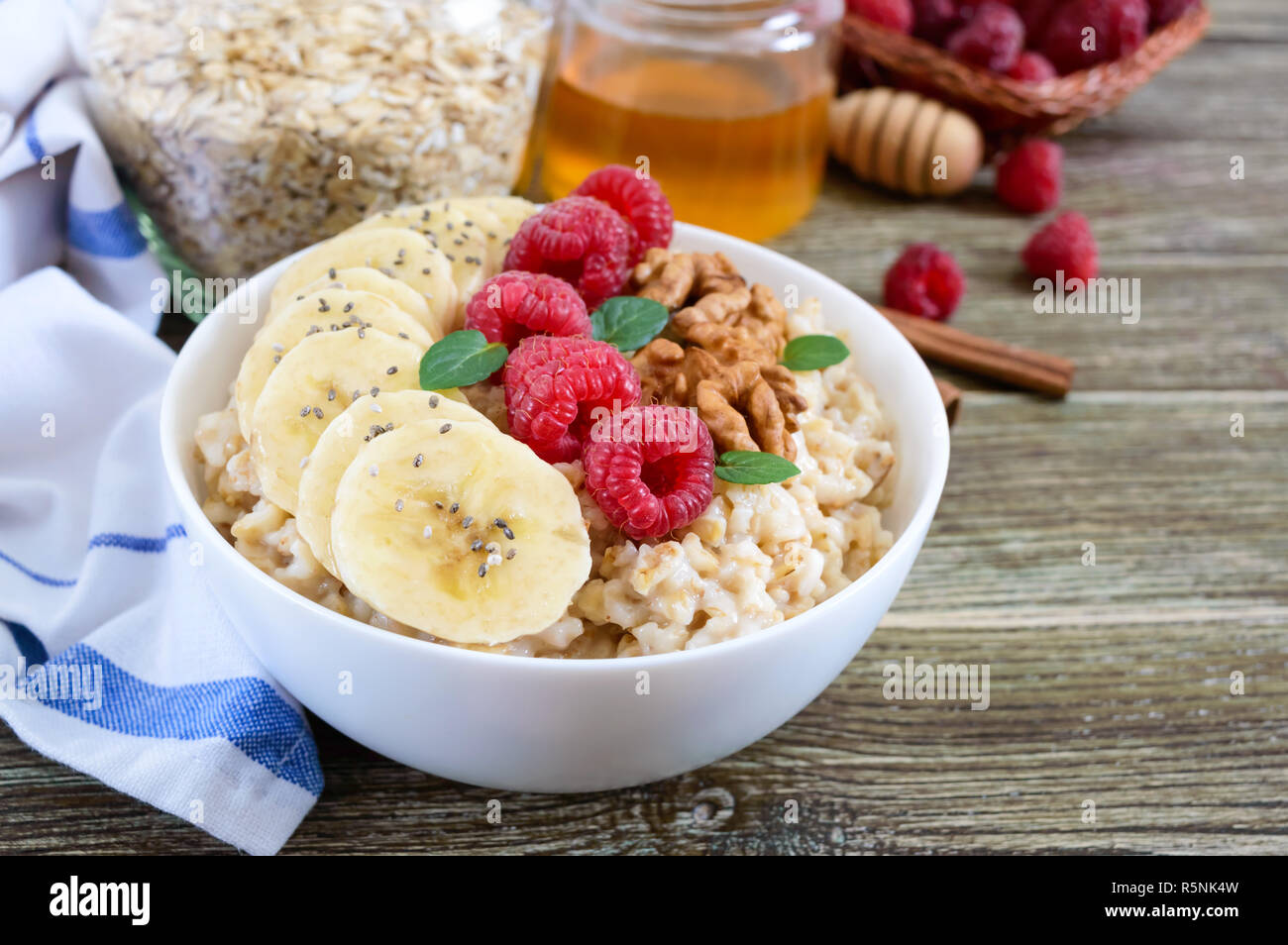 Delizioso e sano di farina di avena con banana, lamponi e dadi. Una sana prima colazione. Cibo per il fitness. Una corretta alimentazione. Foto Stock