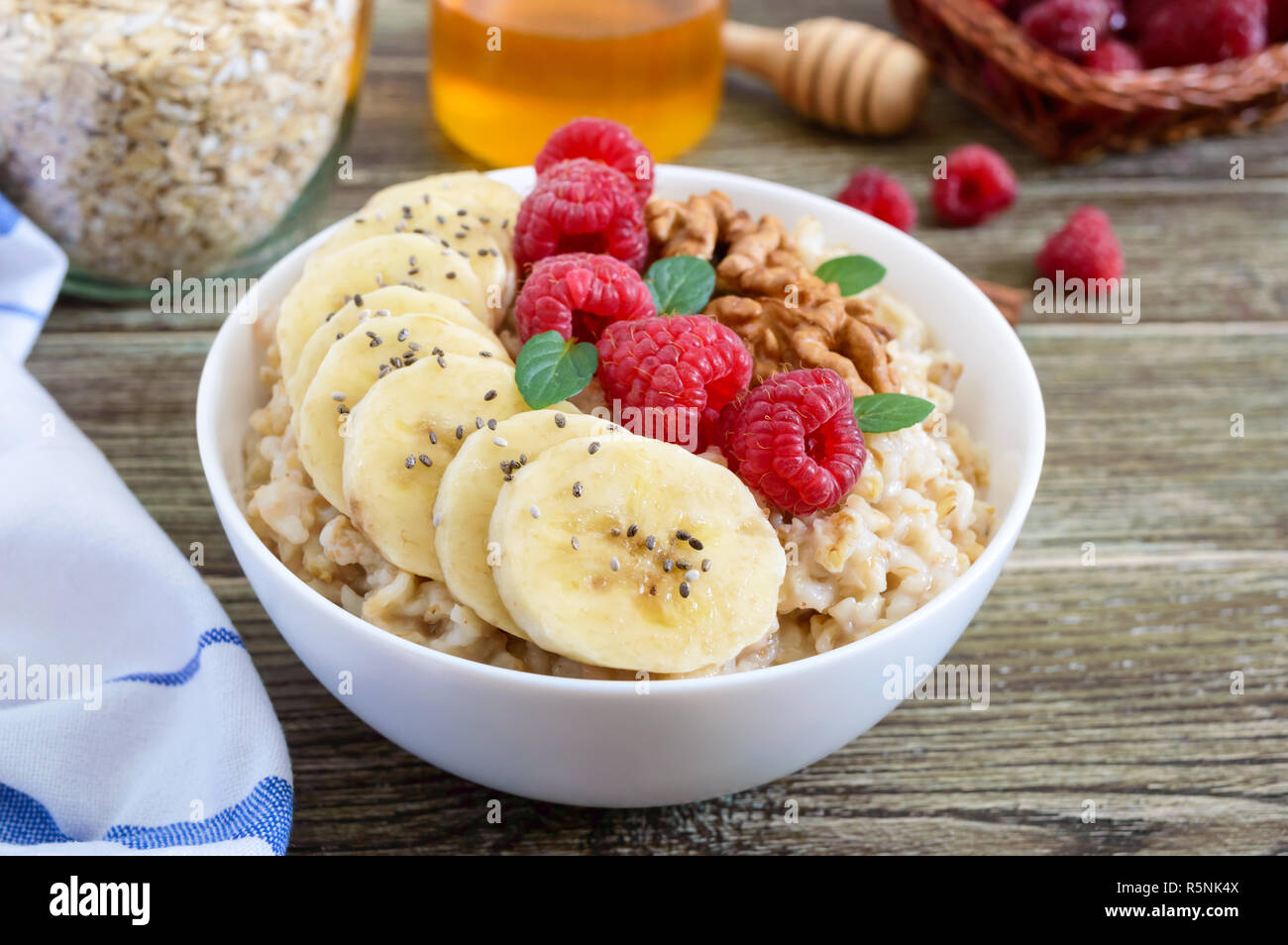 Delizioso e sano di farina di avena con banana, lamponi e dadi. Una sana prima colazione. Cibo per il fitness. Una corretta alimentazione. Foto Stock