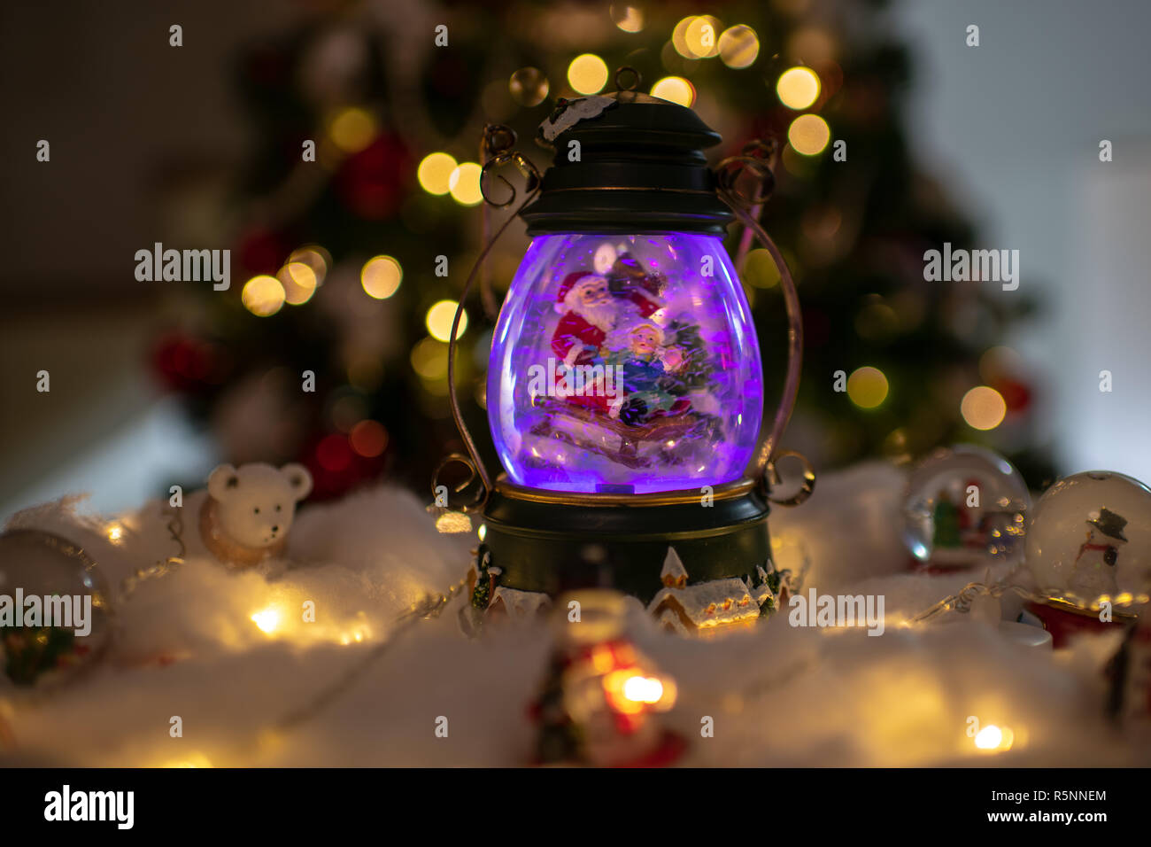 Decorazione di natale, snow dome, globo con decorazioni per la tavola, Santaclaus sulla slitta con il bambino in scena invernale, albero di natale con luci Foto Stock