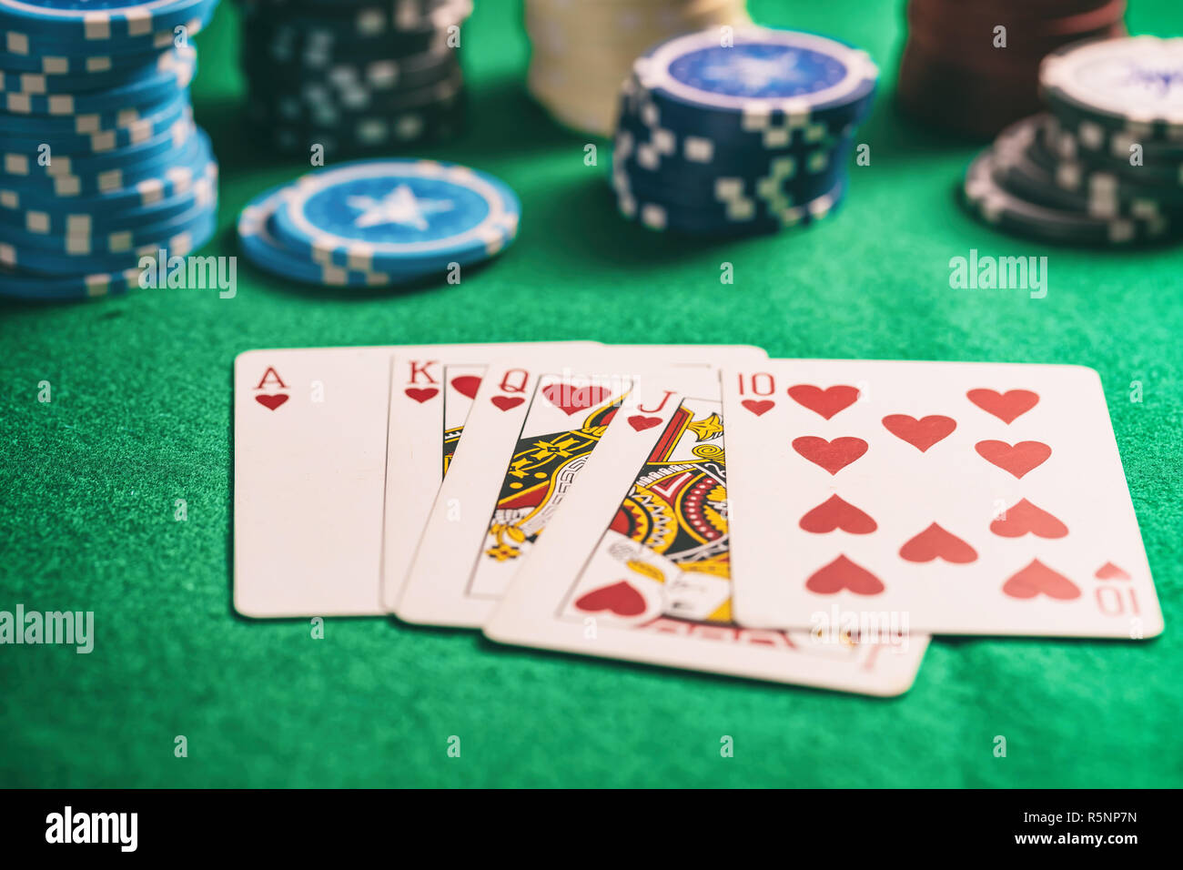 Casinò, il concetto di gioco d'azzardo. Cuori royal flush carte e poker chips sul feltro verde sullo sfondo Foto Stock