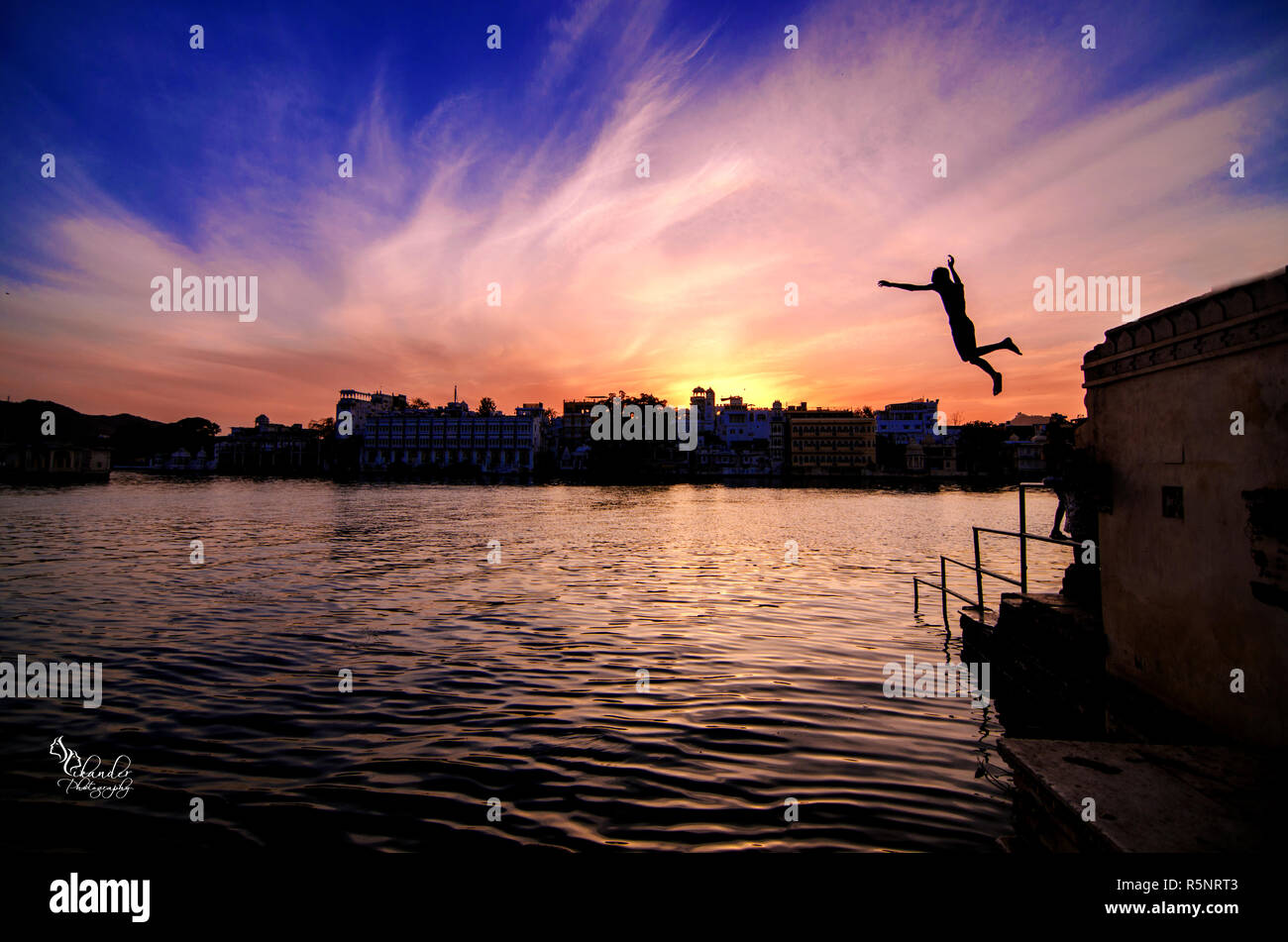 Bambini saltando nel lago Pichola in Udaipur. Ogni giorno è possibile vedere molti dei bambini che giocano in acqua e saltare da questi stadi areound il lago. Foto Stock