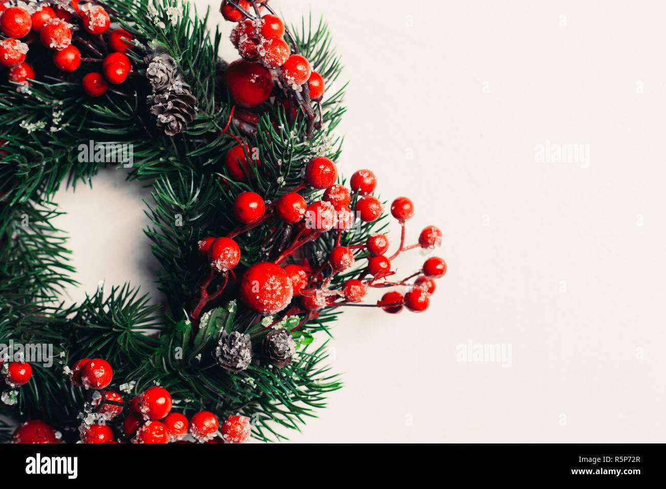 Decorazione di Natale ghirlanda di agrifoglio, edera, vischio, cedro e foglia  di leyland rametti con bacche di colore rosso su sfondo bianco Foto stock -  Alamy