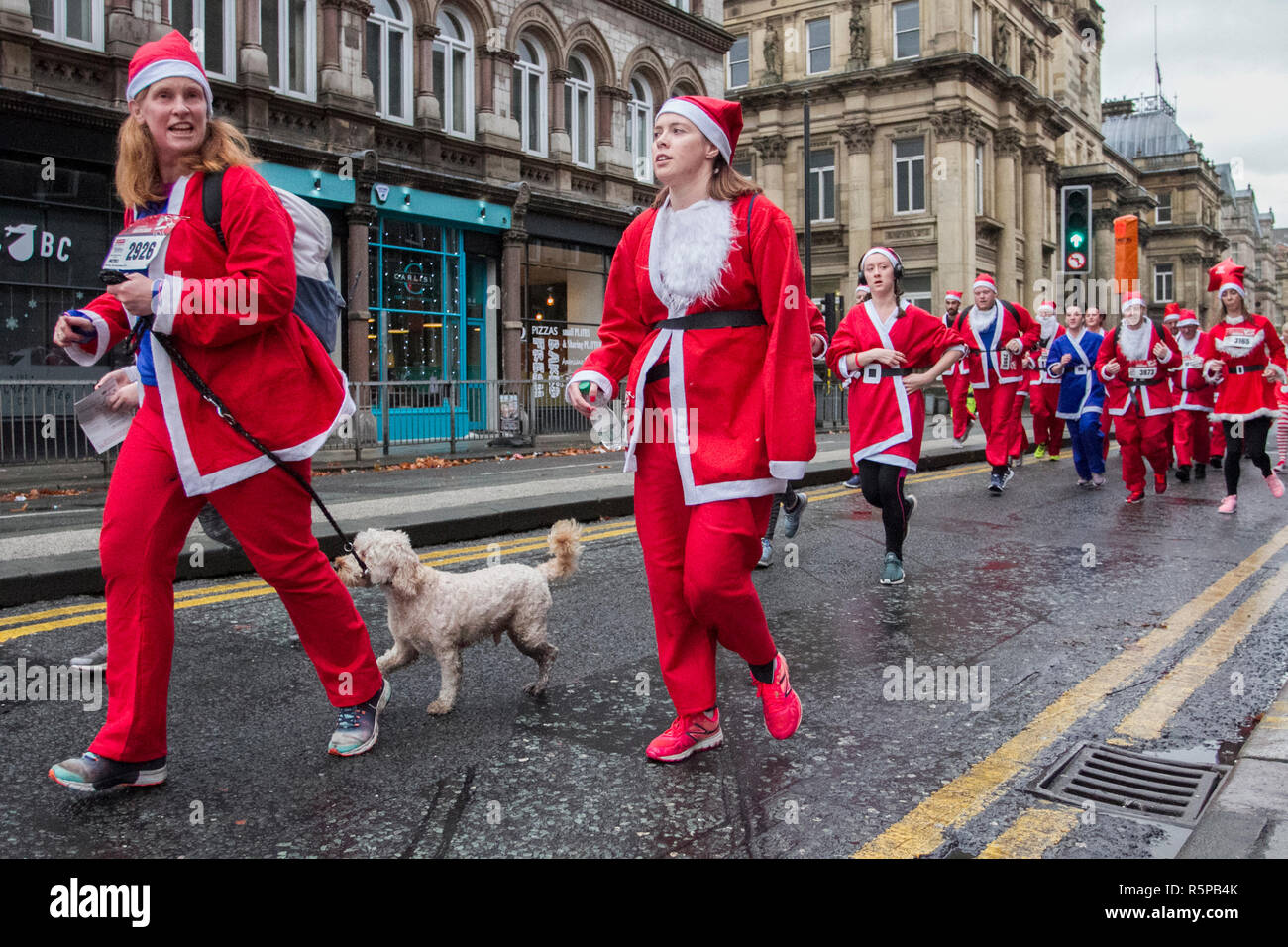 Liverpool, Merseyside, Regno Unito. 2 Novembre 2018. BTR Liverpool Santa Dash. I cittadini di Merseyside festeggiano il ritorno della più grande corsa festiva del Regno Unito, la 5K. L'evento festivo ha continuato a crescere con la partecipazione di 10,000 runner, Red, Blue Santas quest'anno. Il percorso ha preso le sante Santas attraverso il centro della città, prima che hanno attraversato la linea di arrivo fuori del Municipio, dove sono stati accolti da una miriade di personaggi festosi. Credit:MediaWorldImages/AlamyLiveNews. Foto Stock