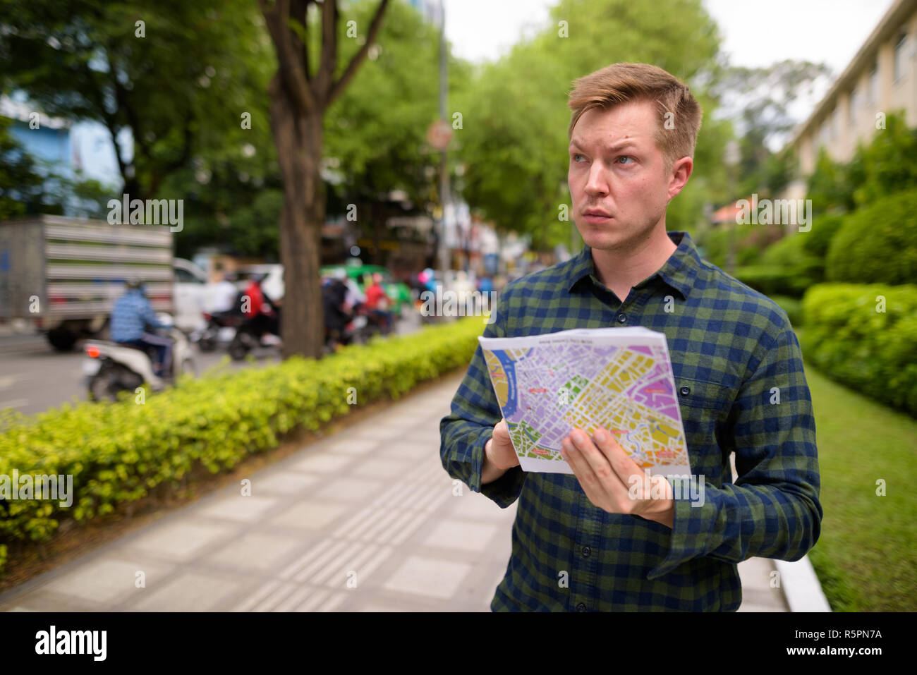 Uomo turistico ad esplorare la città di Ho Chi Minh in Vietnam e azienda mappa Foto Stock