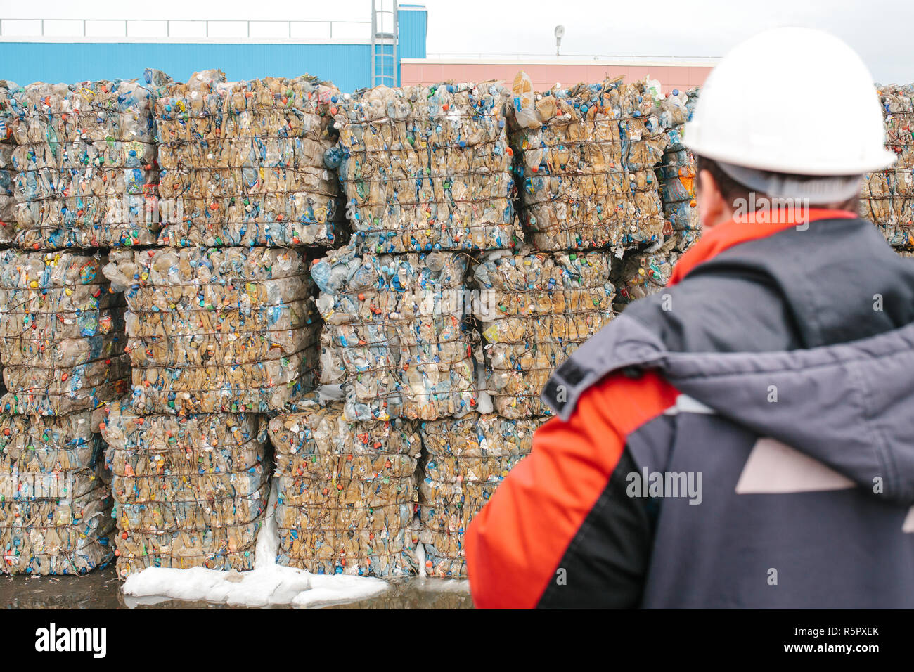 Impianto di trattamento dei rifiuti. Il processo tecnologico per accettazione, di storage, di cernita e di ulteriore trattamento di rifiuti per il loro riciclo. Messa a fuoco selettiva. Il lavoratore è al di fuori della messa a fuoco o sfocata. Foto Stock