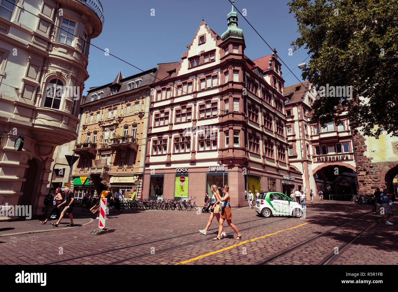 Freiburg im Breisgau, Baden-Württemberg, Germania - 30 luglio 2018 : intersezione nei pressi del Martin's Gate (Martinstor) con persone che passeggiano e piccoli ele Foto Stock