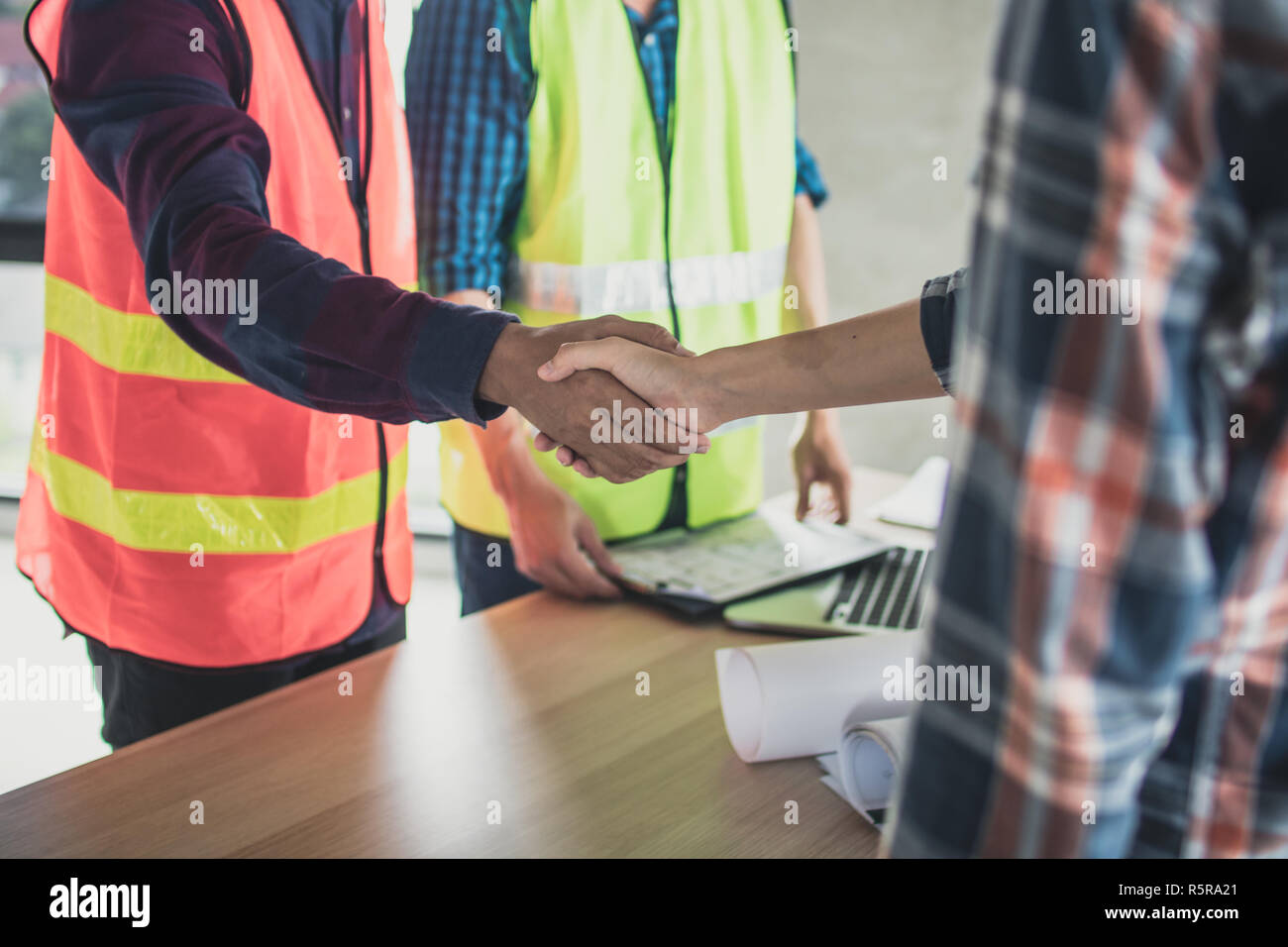 Ingegnere e lavoratore agitare le mani prima di piallatura e parlando costruzione dell'edificio. Foto Stock