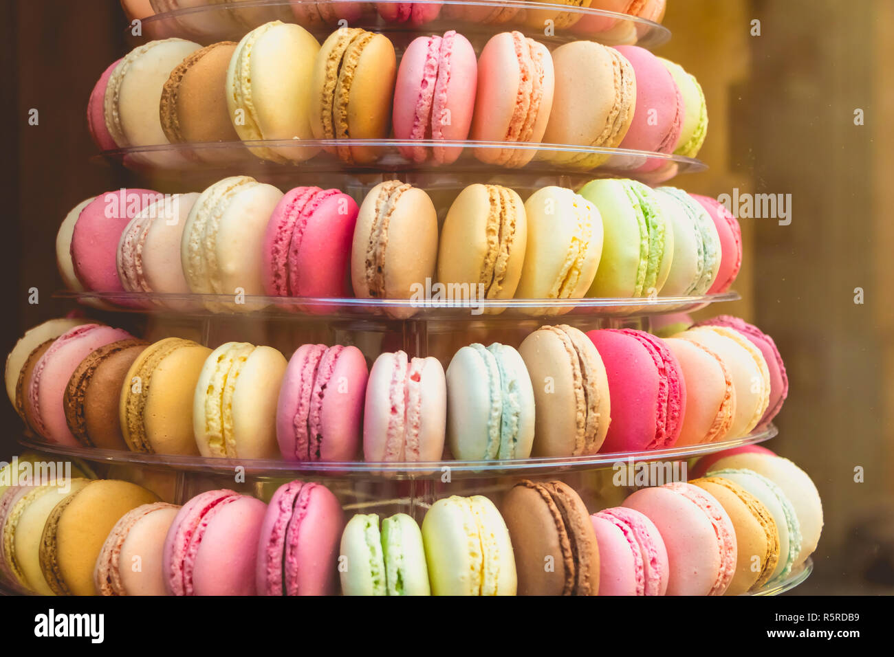 Stuzzicanti macarons multicolor nella vetrina del negozio Foto Stock