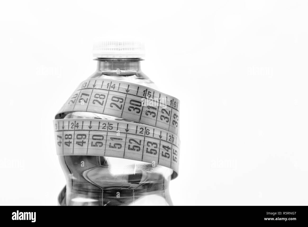 Nella luce bianca e spazio copia una bottiglia di acqua minerale e rosso nastro di misura come il concetto di stile di vita e alla dieta Foto Stock