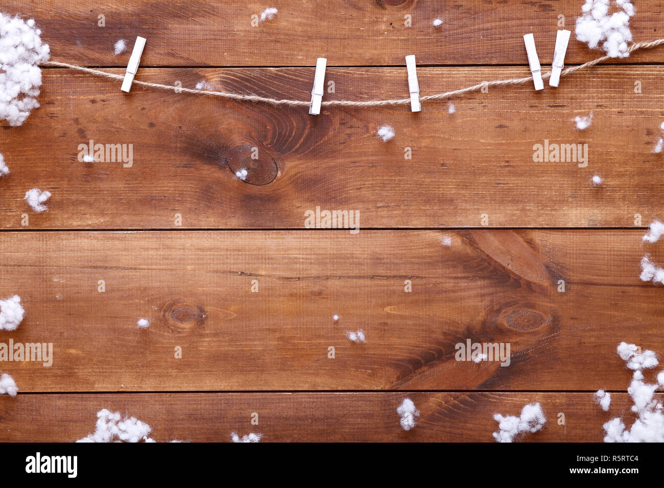 Legno marrone tabella di sfondo con fiocchi di neve bianca e su di essa, vacanze invernali concetto card, buon Natale e felice anno nuovo celebrazione, winterime Foto Stock