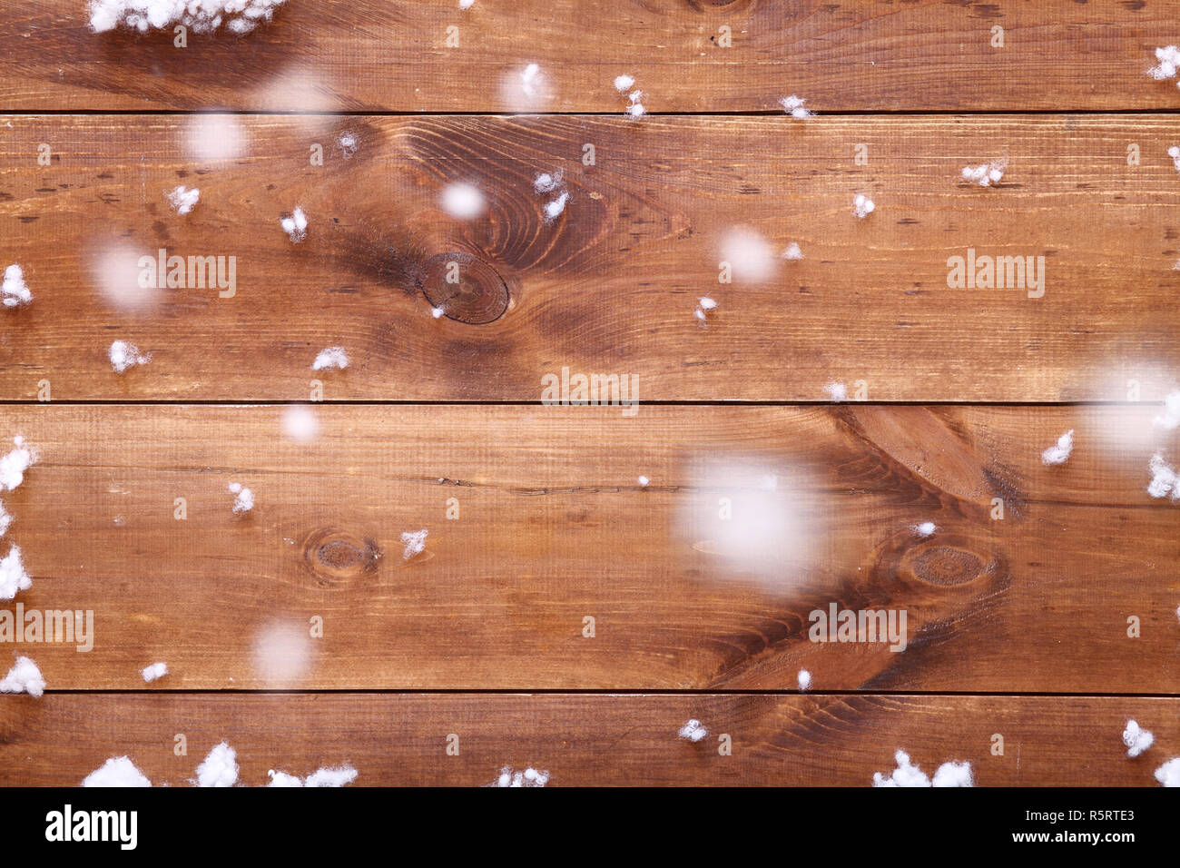 Luce di legno marrone tabella di sfondo bianco con i fiocchi di neve, vuoto vuoto pannello di legno tavole desk coperto con la caduta di neve, vacanze invernali card, merry C Foto Stock