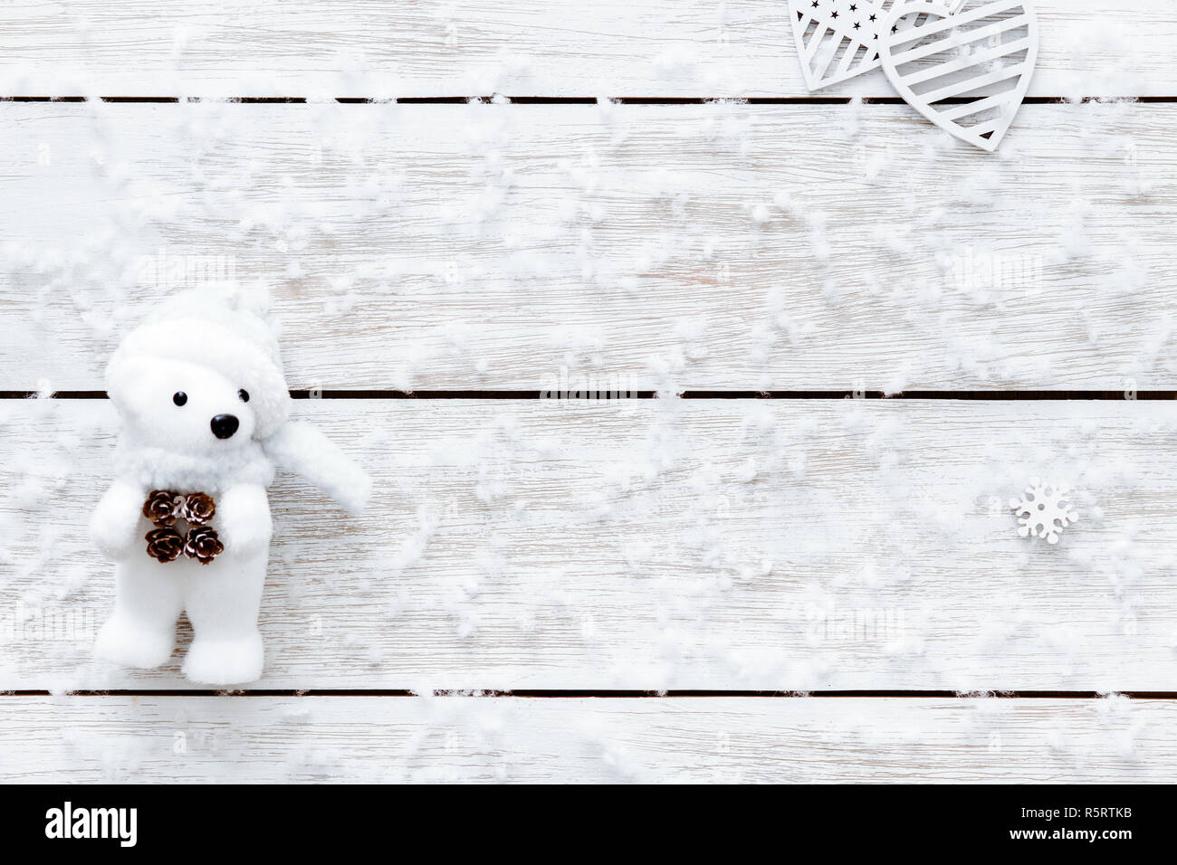 I fiocchi di neve, cuori e toy portano sul tavolo di legno, bianco fiocchi di neve sulla luce xmas desk, buon Natale vacanza o un romantico San Valentino backgroun Foto Stock