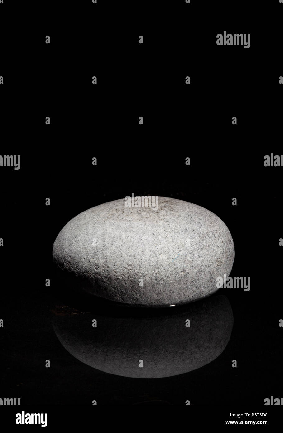 Singola pietra - sfondo scuro - concetto zen Foto Stock