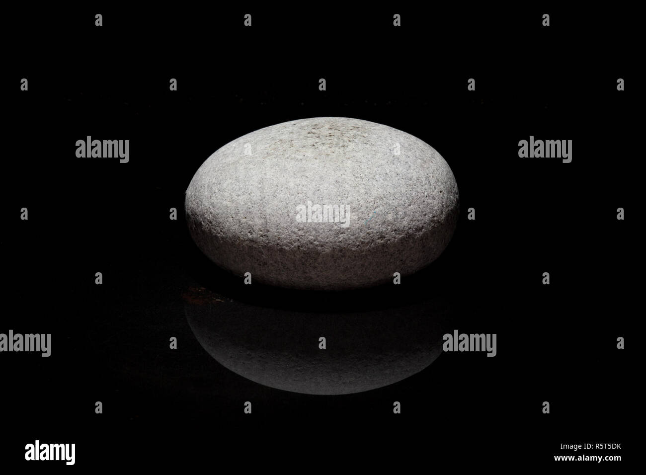 Singola pietra - sfondo scuro - concetto zen Foto Stock