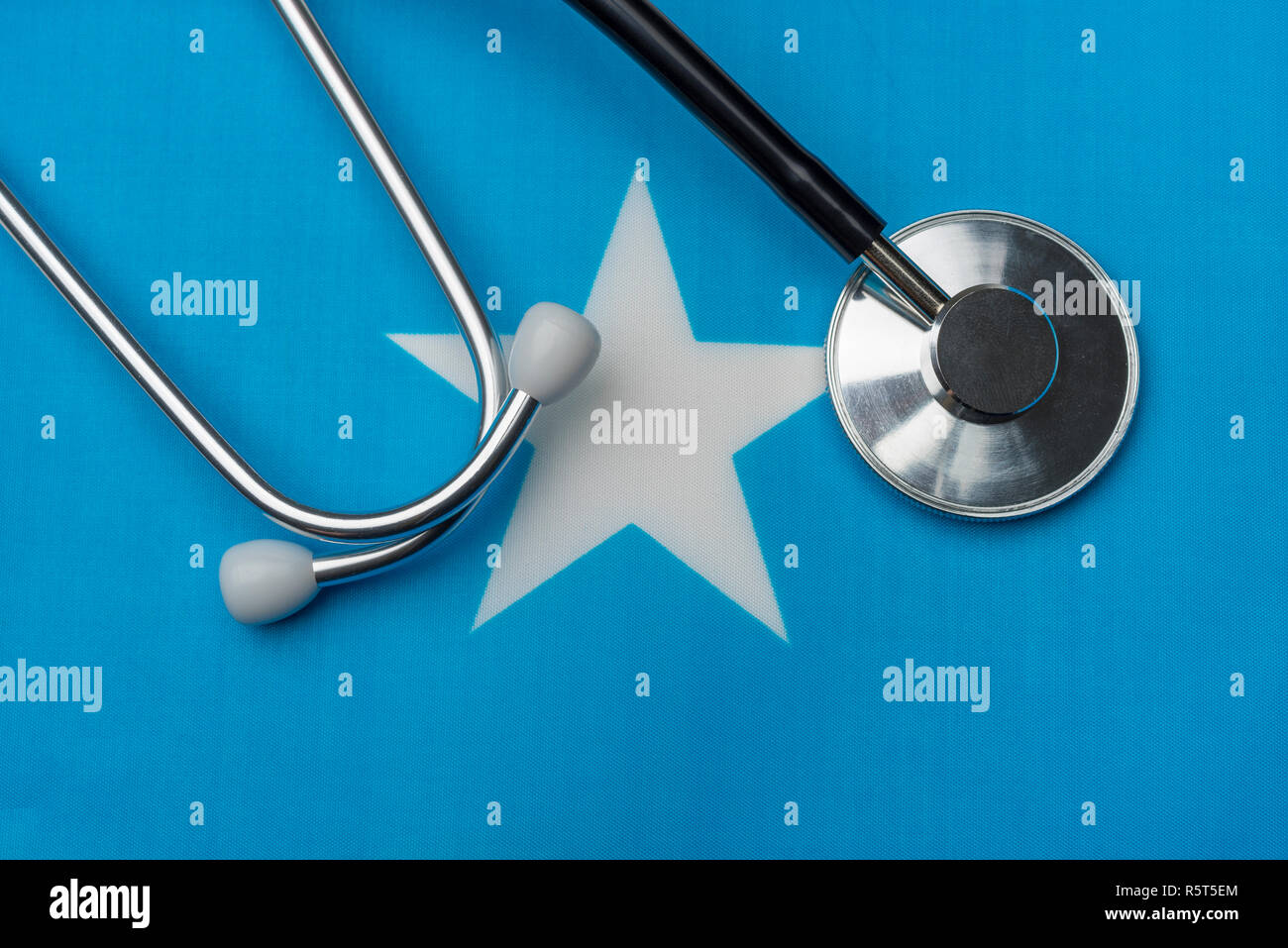 Bandiera somala e stetoscopio. Il concetto di medicina. Lo stetoscopio sulla bandiera come sfondo. Foto Stock